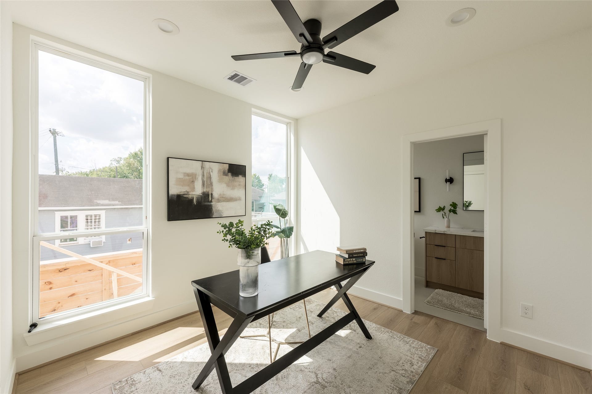 2009 Gregg Street, Houston, TX 77026 Bright, modern office space with large windows, sleek ceiling fan, and direct access to a stylish bathroom.