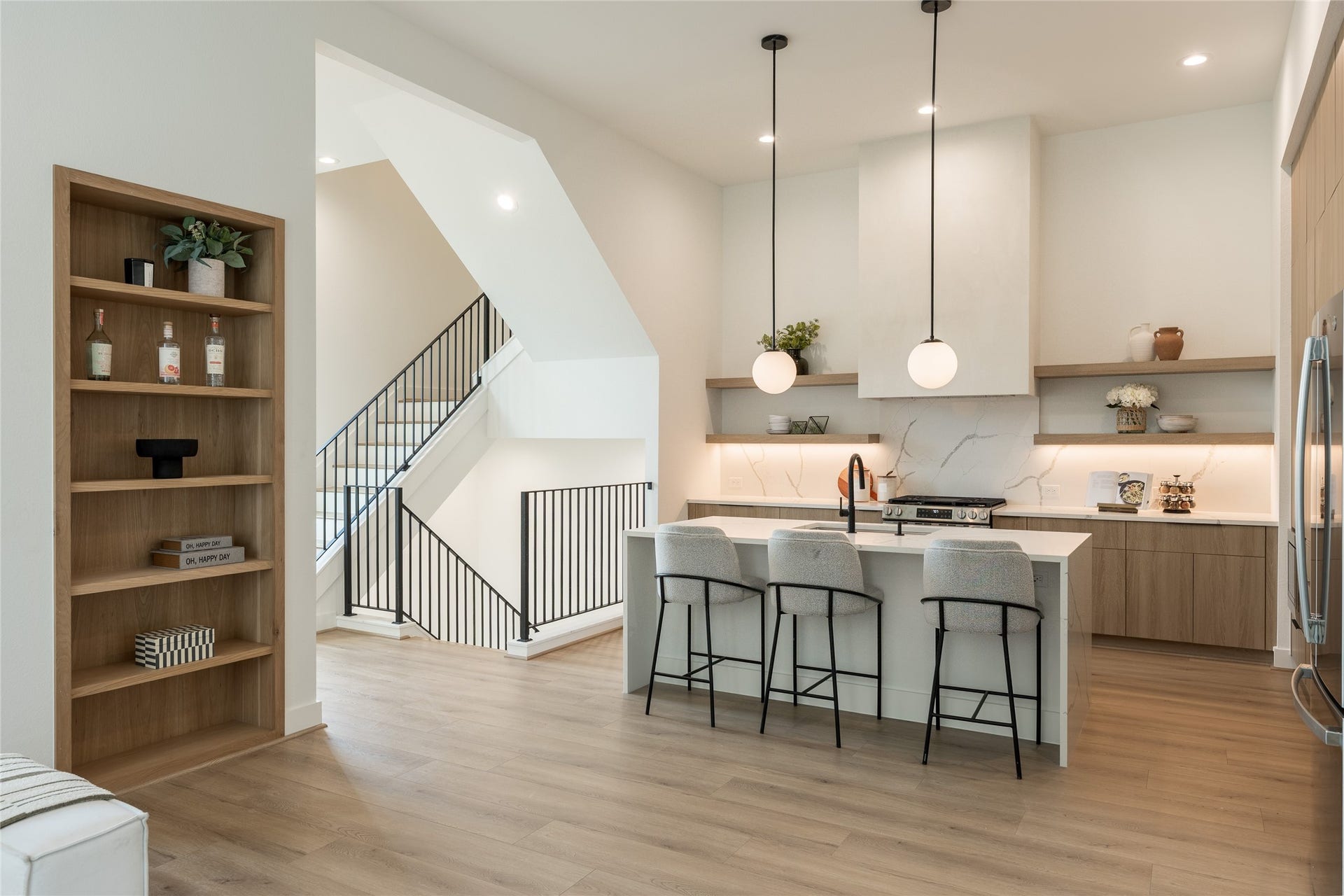 2009 Gregg Street, Houston, TX 77026 Modern kitchen with sleek cabinetry, a spacious island, and stylish pendant lighting. The open layout features light flooring and a decorative built-in shelving unit.