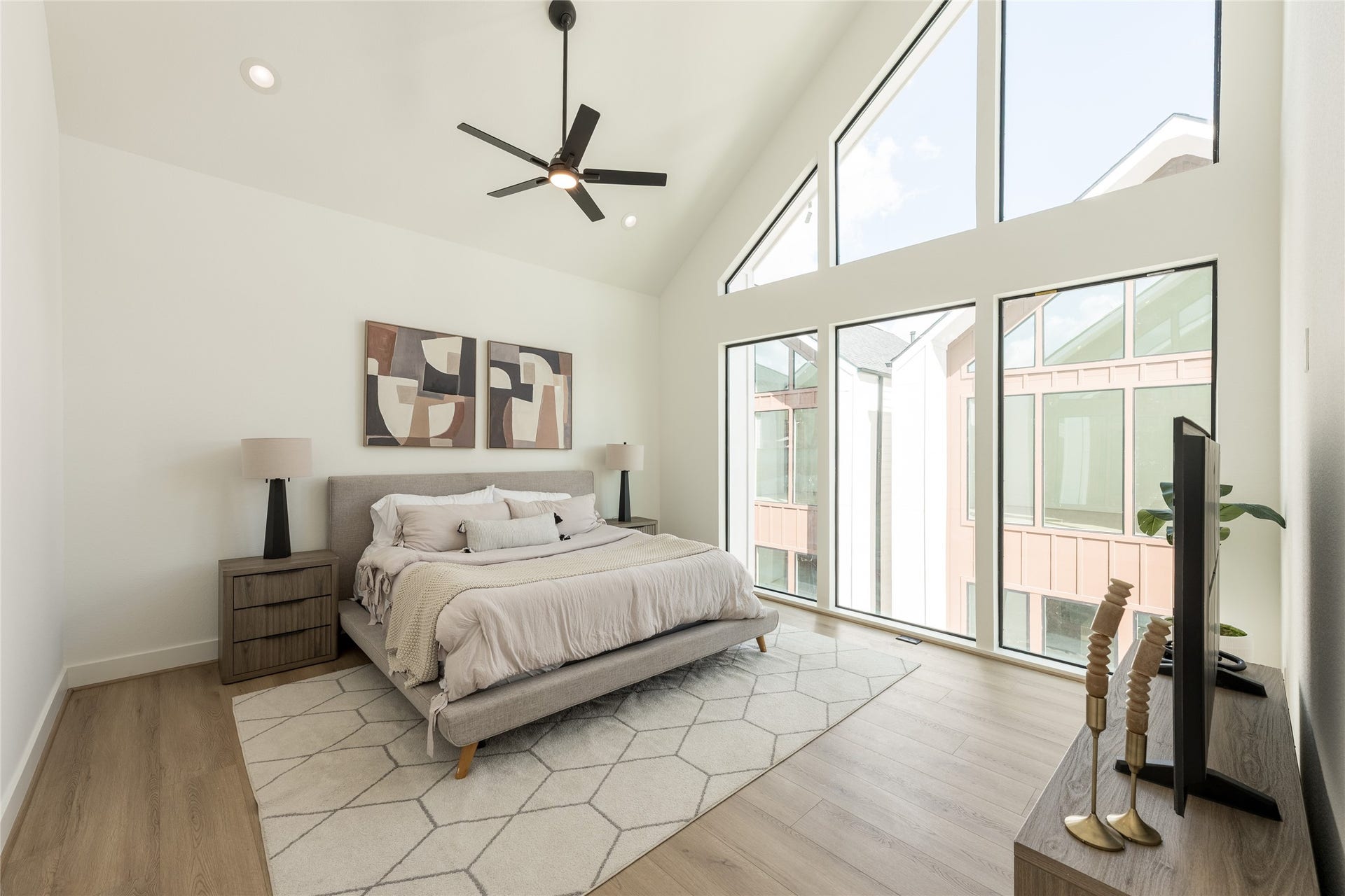 2009 Gregg Street, Houston, TX 77026 Experience modern elegance in this spacious primary bedroom, featuring vaulted ceilings, expansive windows for abundant natural light