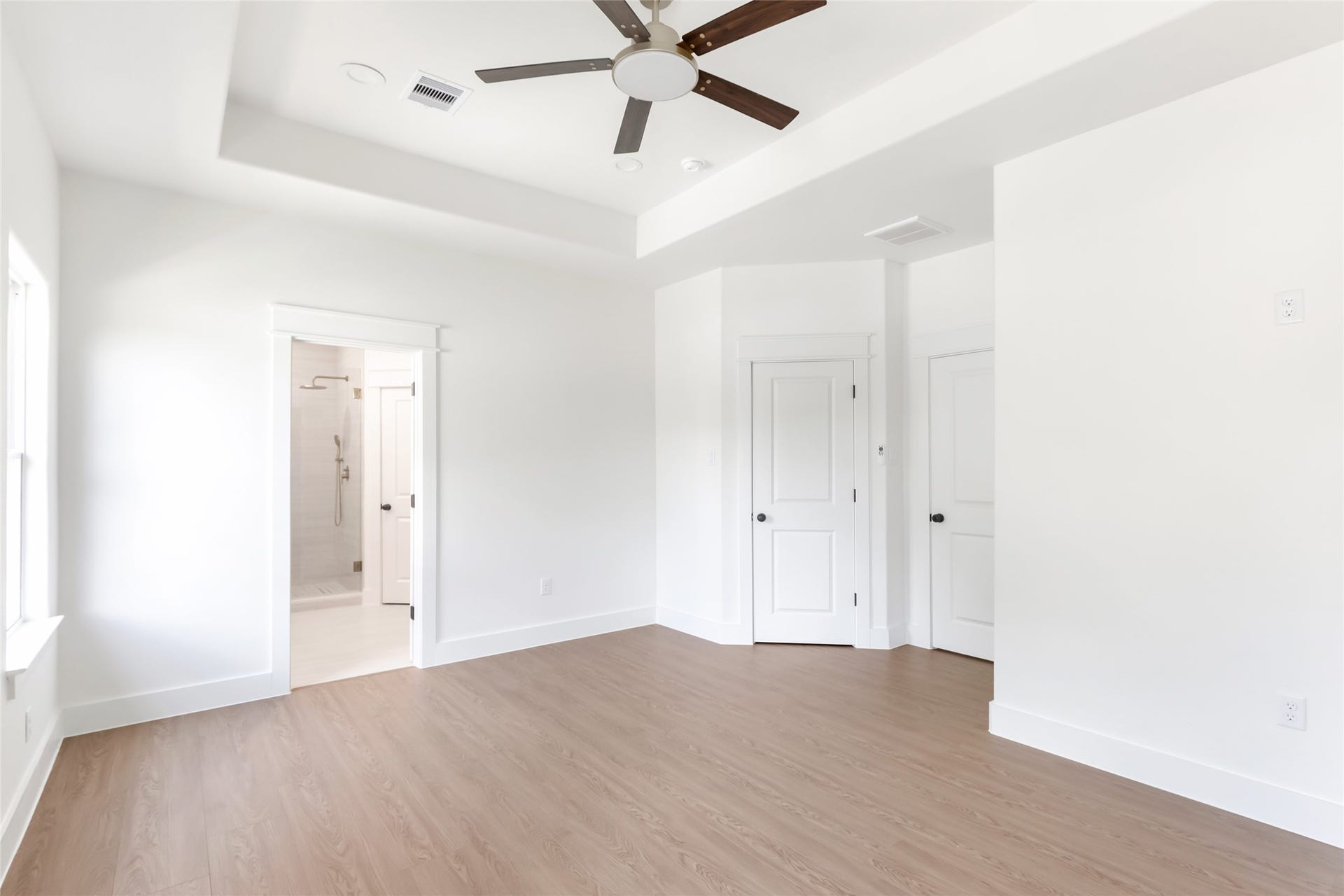 Primary ensuite with tray ceiling and attached bathroom.
