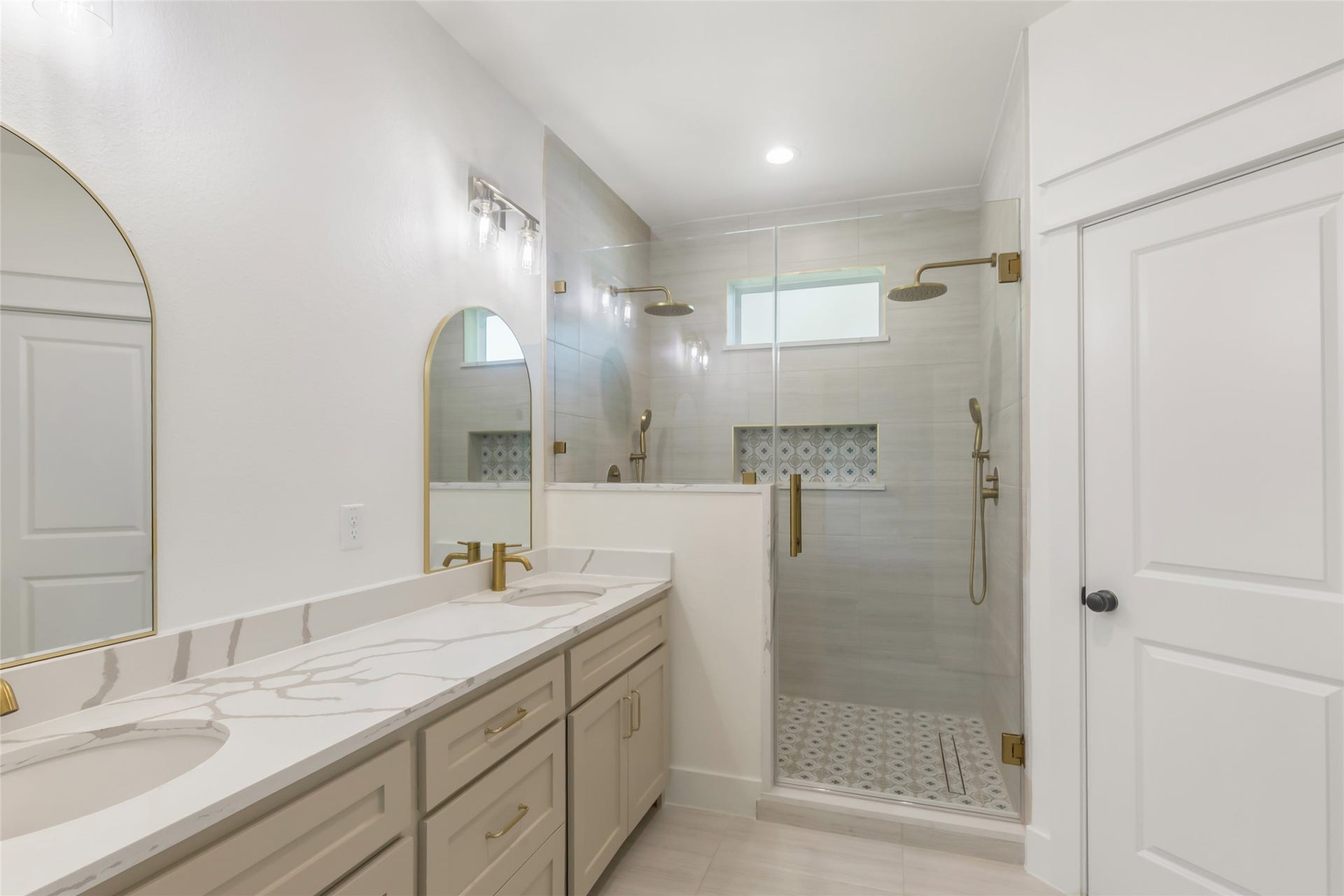 Primary bath has double sink vanity and an elegant shower featuring dual shower heads for a spa-like retreat.