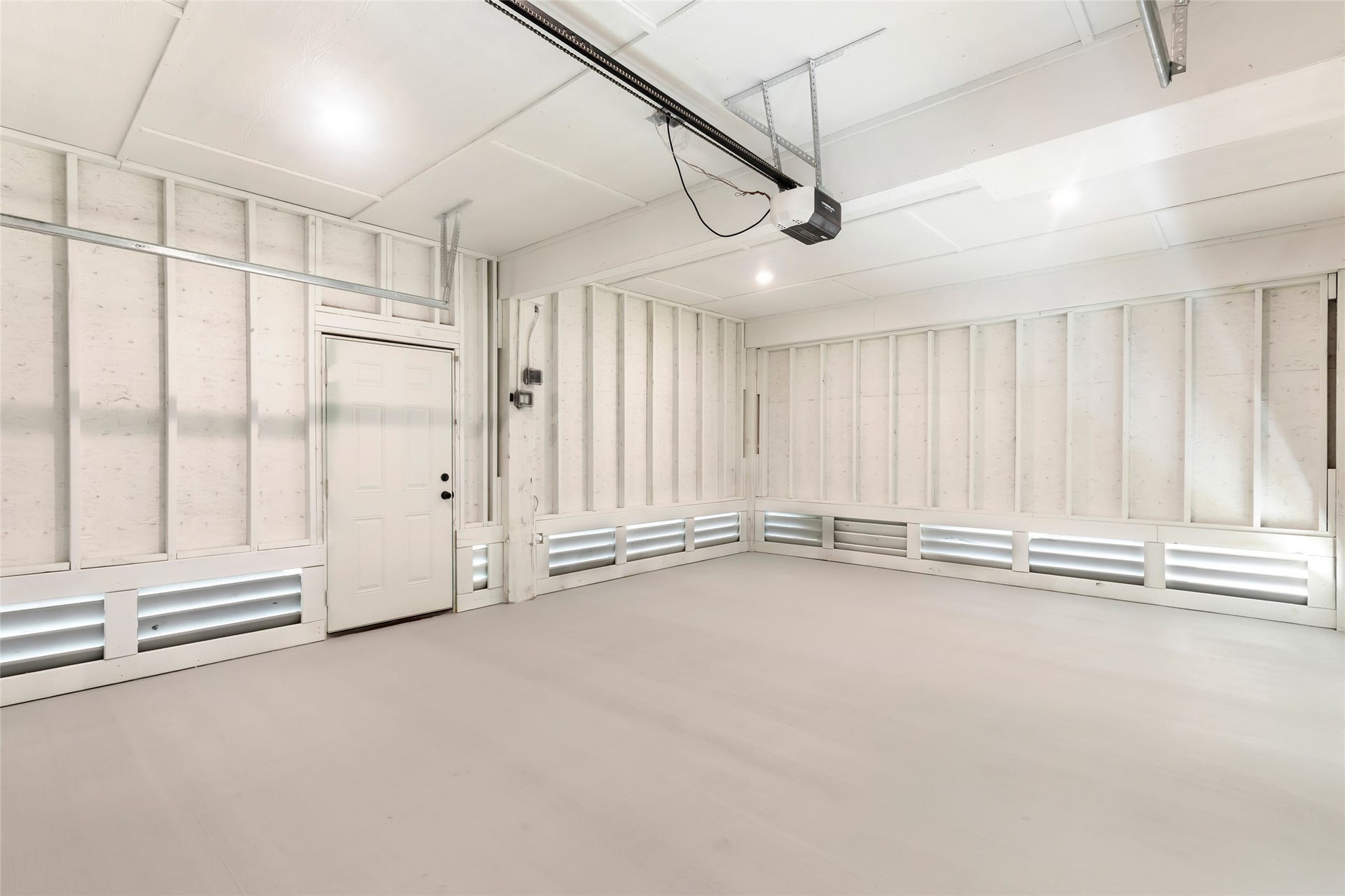 Spacious, well-lit garage with clean, white walls and ample storage potential.
