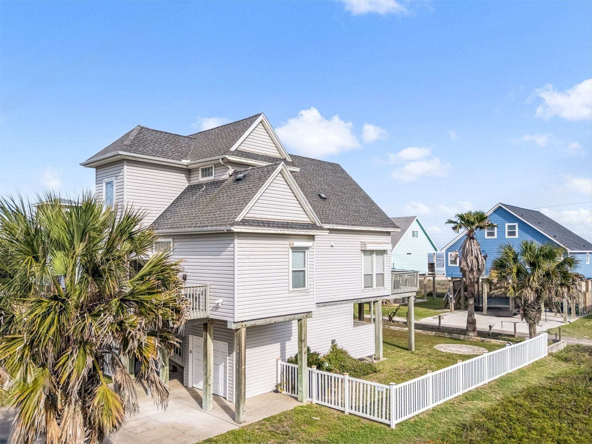 21519 San Luis Pass Road, Galveston, TX 77554 The property offers a partially fenced yard, open to the beach access. The wide driveway provides extra parking space and the 1-car garage is great for enclosed parking or ample storage space.