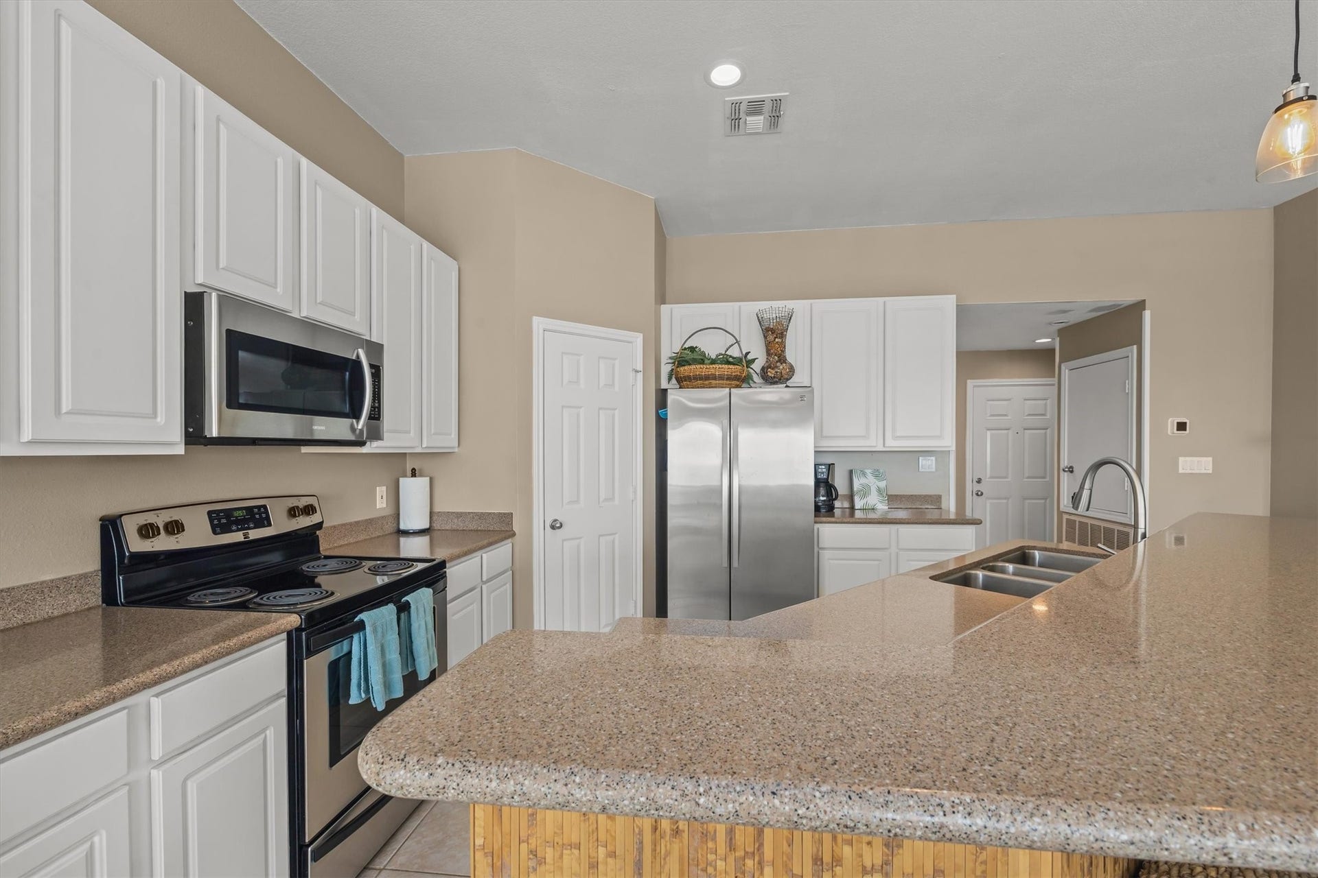 21519 San Luis Pass Road, Galveston, TX 77554 The modern kitchen features ample counter space with stainless steel appliances, white cabinetry, and a spacious island with a double sink. The layout offers a clean and functional design, ideal for cooking and entertaining.