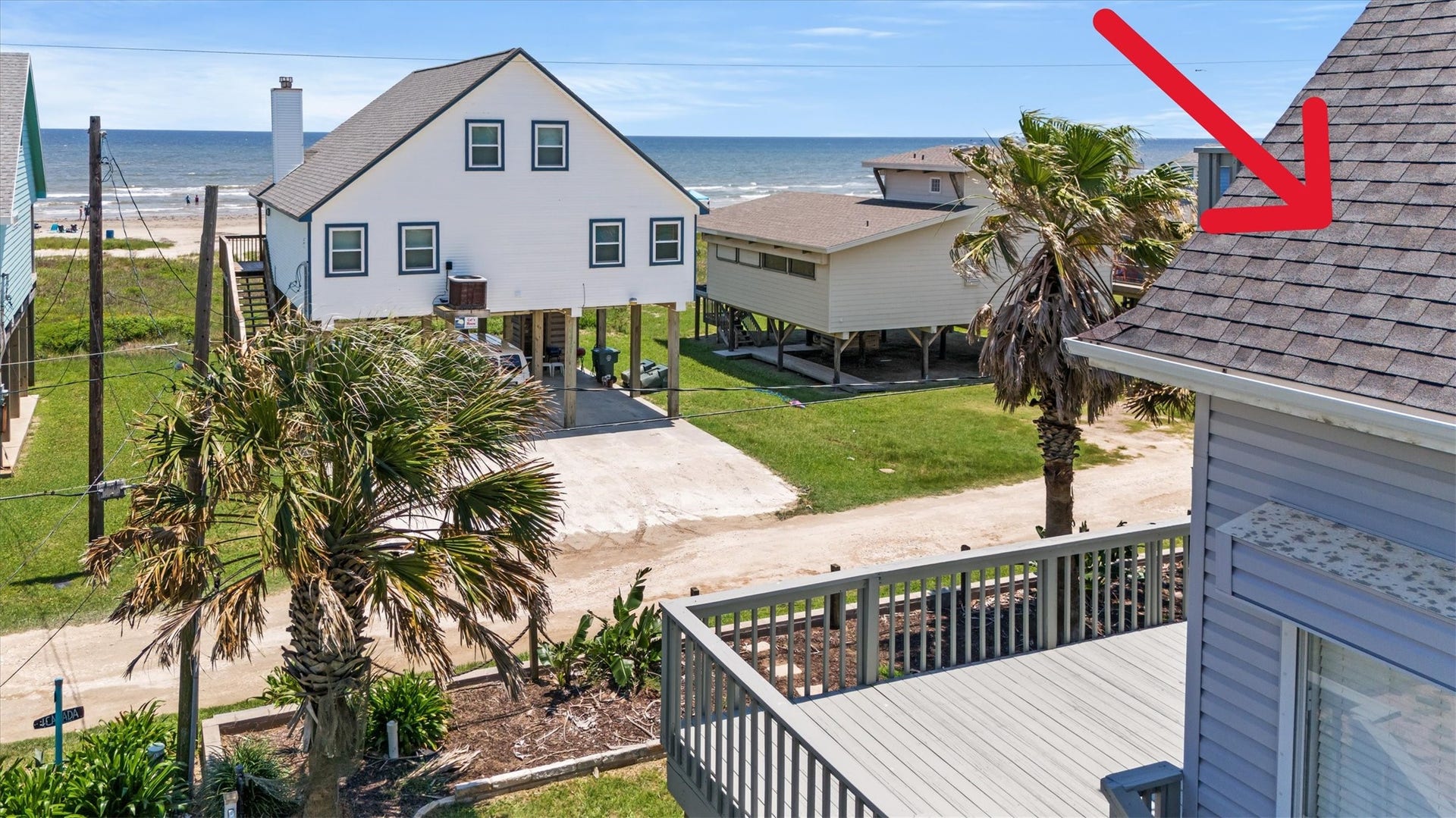 21519 San Luis Pass Road, Galveston, TX 77554 The spacious deck provides great ocean views, surrounded by palm trees. The elevated design offers direct access to a sandy road leading to the beach. Ideal for enjoying seaside living.