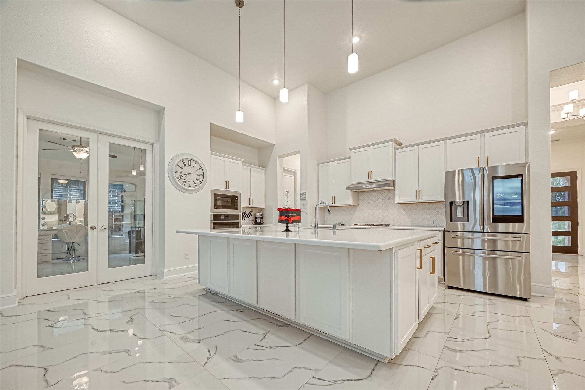 12215 Mackinchan Street, Richmond, TX 77407 A chefs dream kitchen featuring an oversized statement island and upgraded cabinetry adorned with elegant hardware and crown molding, delivering a luxurious blend of timeless craftsmanship and sophisticated design