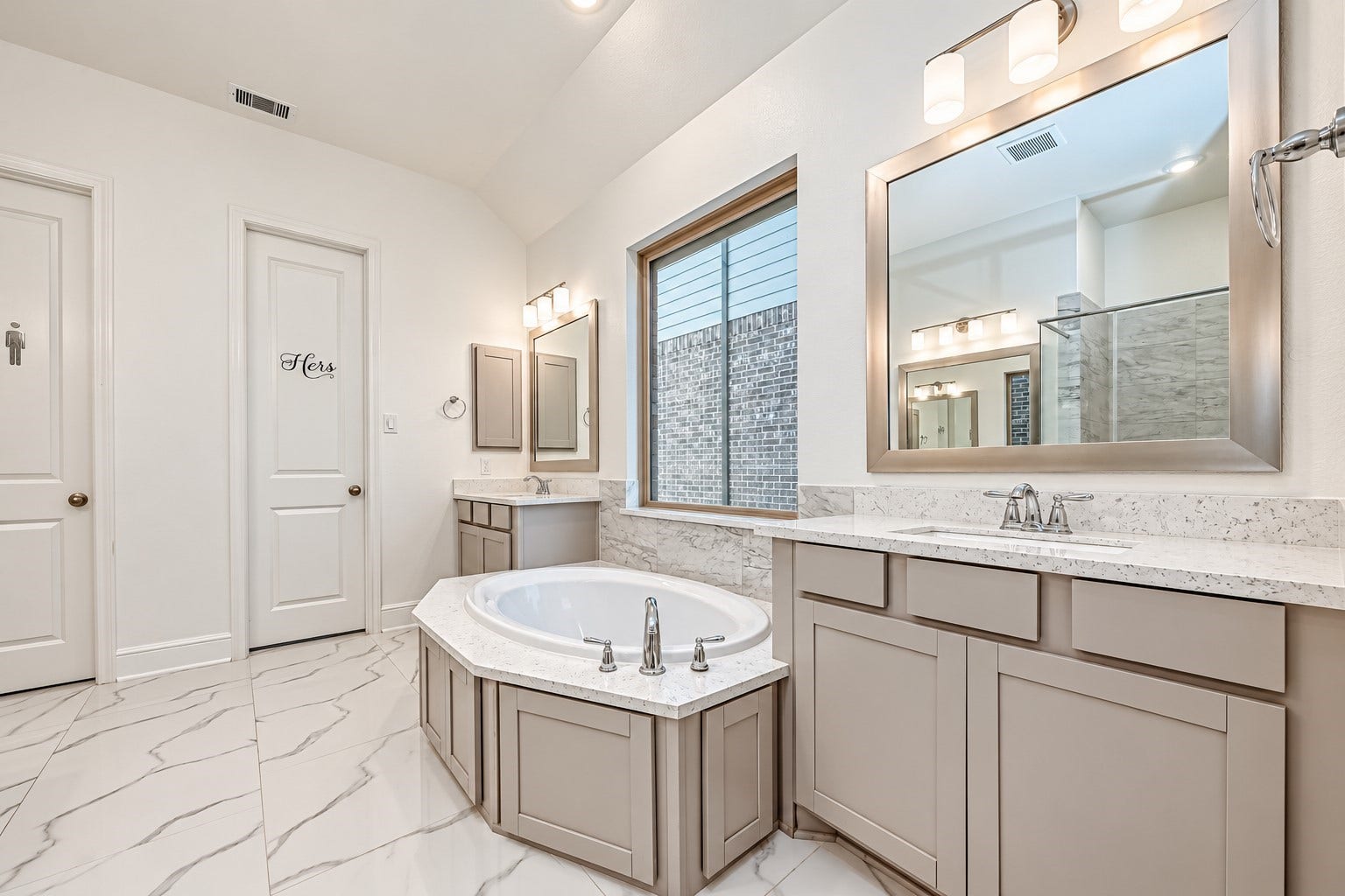 12215 Mackinchan Street, Richmond, TX 77407 An modern primary bathroom designed for a spa-like experience, featuring elegant double vanities, a sleek glass-enclosed shower, and a luxurious soaking tub, creating a sophisticated sanctuary for relaxation and indulgence