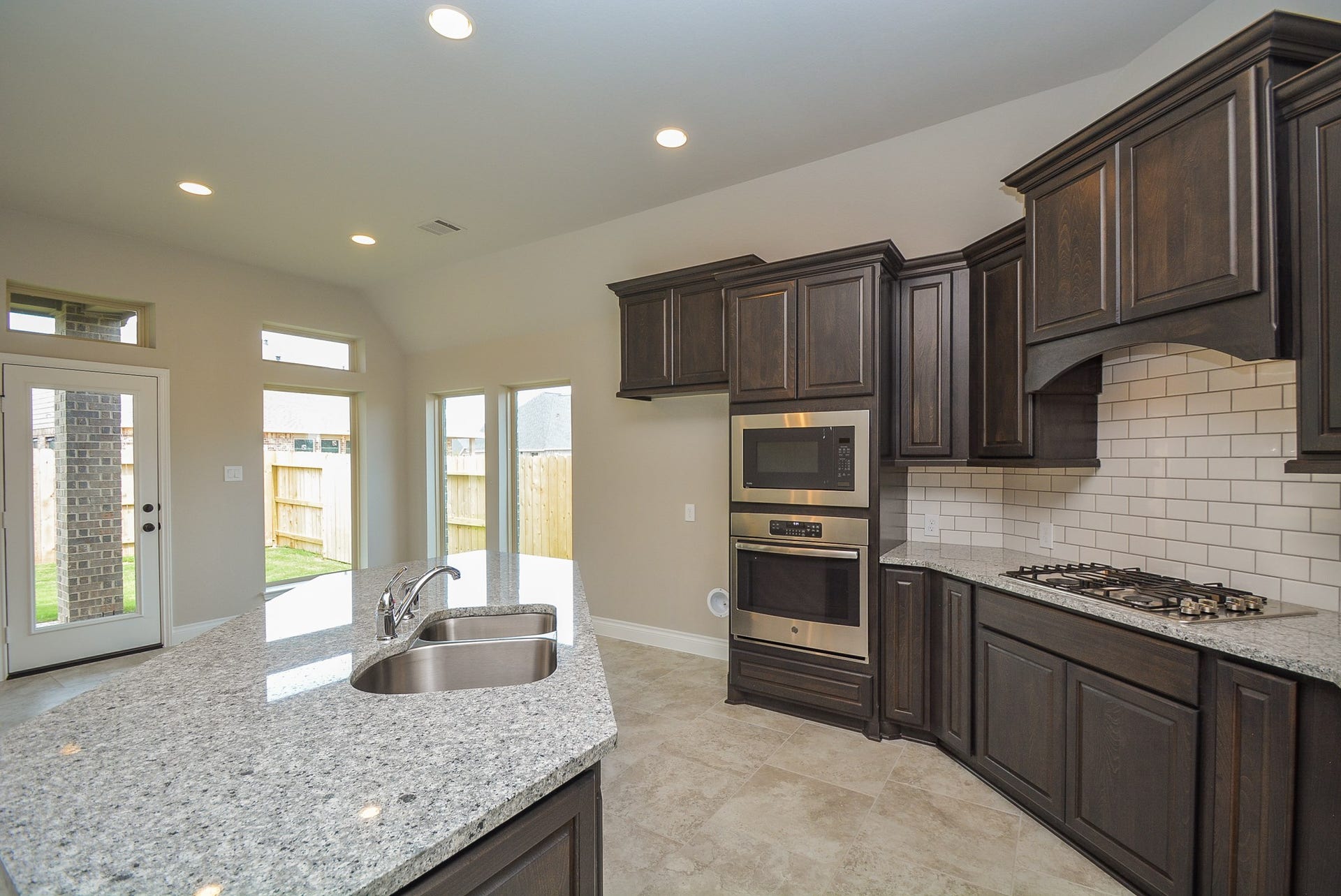 Island kitchen with Granite countertop, microwave, and oven