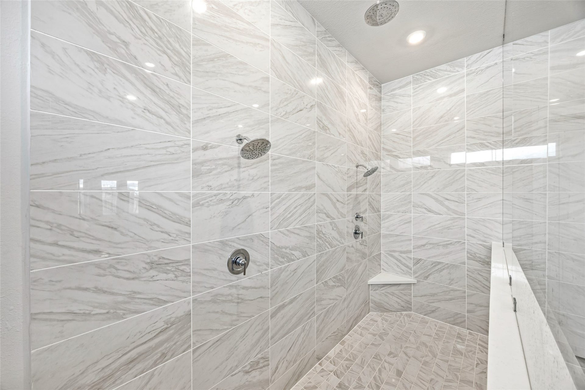 An elegant, oversized shower featuring three showerheads for ultimate comfort and luxury
