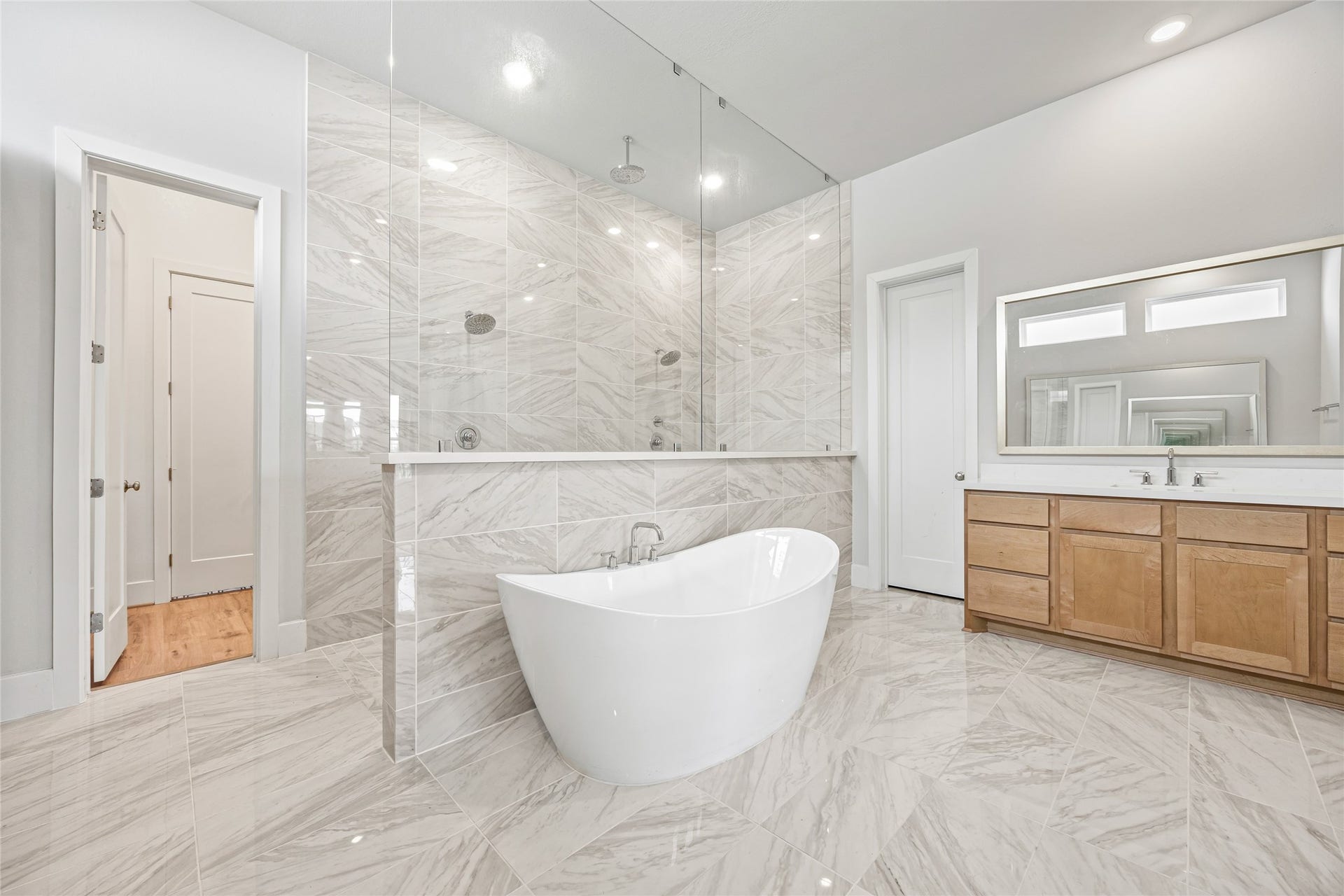 Opulent master bathroom boasts a grand double-wide shower and an exquisitely angled soaking tub, creating a spa-like retreat