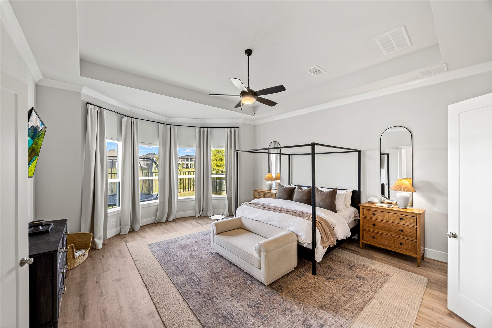 A gorgeous, expansive master bedroom that feels regal, complete with calming water views
