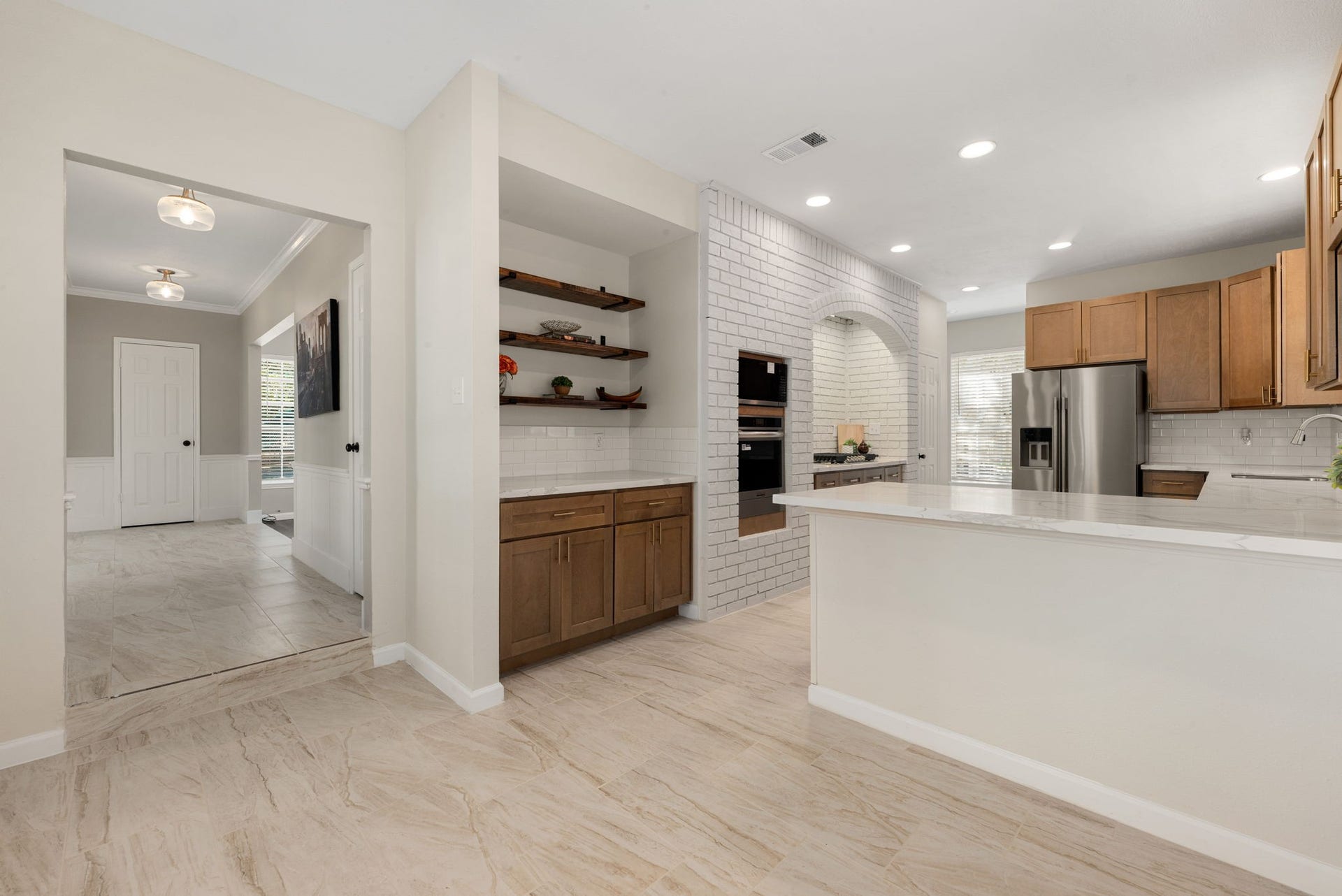 Designed for both everyday convenience and entertaining, the kitchen offers generous counter space, breakfast bar seating, and an easy connection to the living areas.