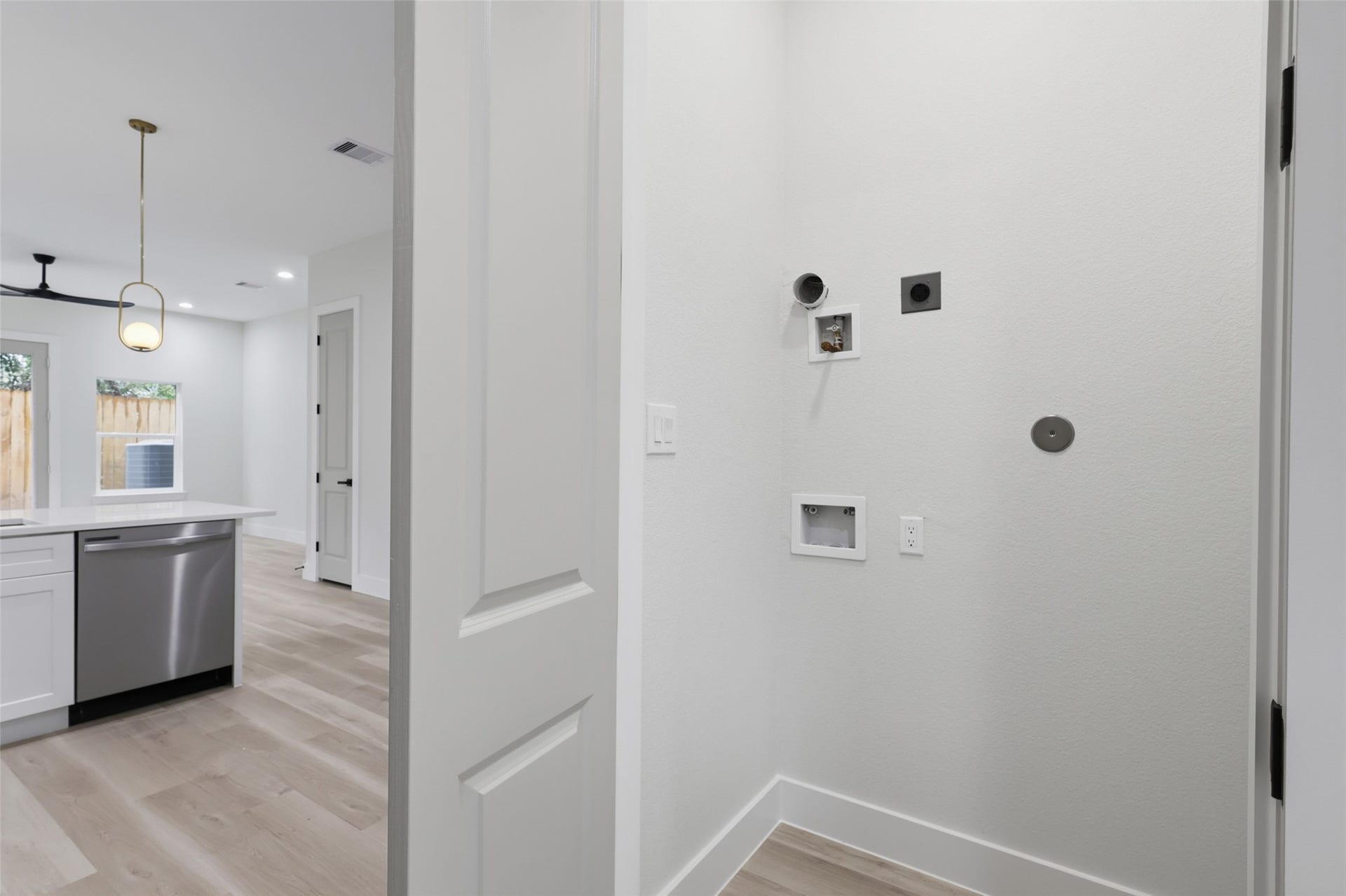 3201 & 3205 Berry Street, #A/B, Houston, TX 77004 Bright and modern utility area with hookups for laundry, adjacent to an open-concept kitchen, located on the first floor, featuring sleek appliances and stylish lighting.