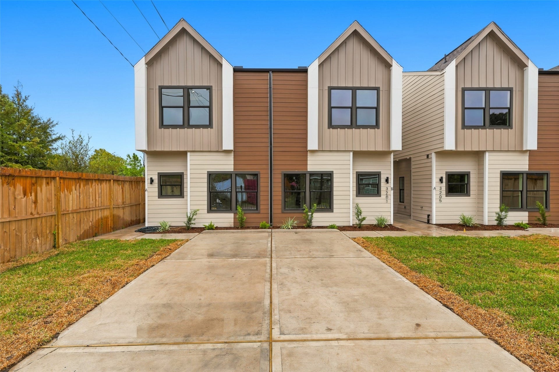 3201 & 3205 Berry Street, #A/B, Houston, TX 77004 Modern duplexes featuring a stylish exterior with clean lines, gated driveway, and a lush green lawn, offering both security and curb appeal.