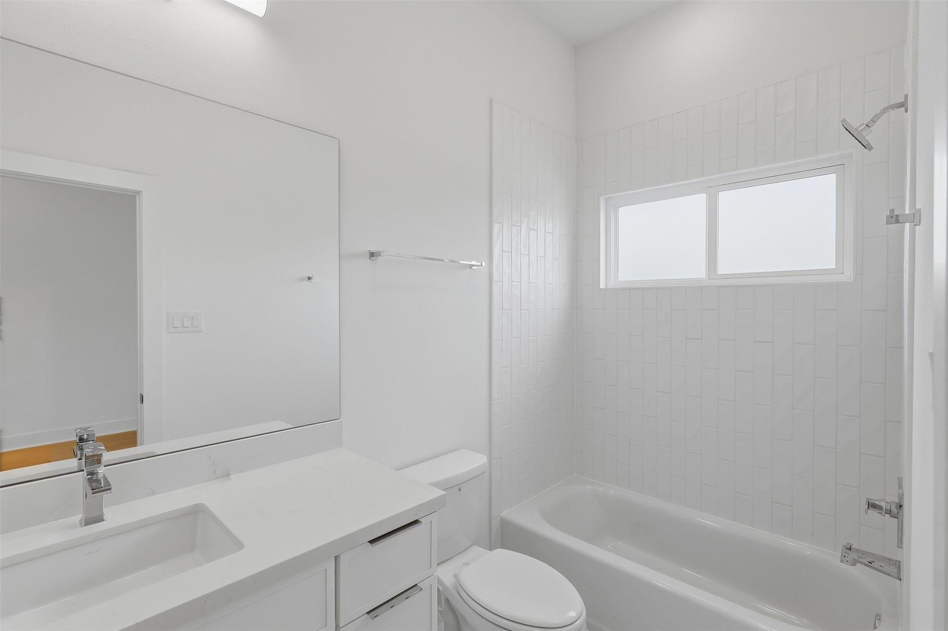 The nearby bathroom includes a tub and shower combination.