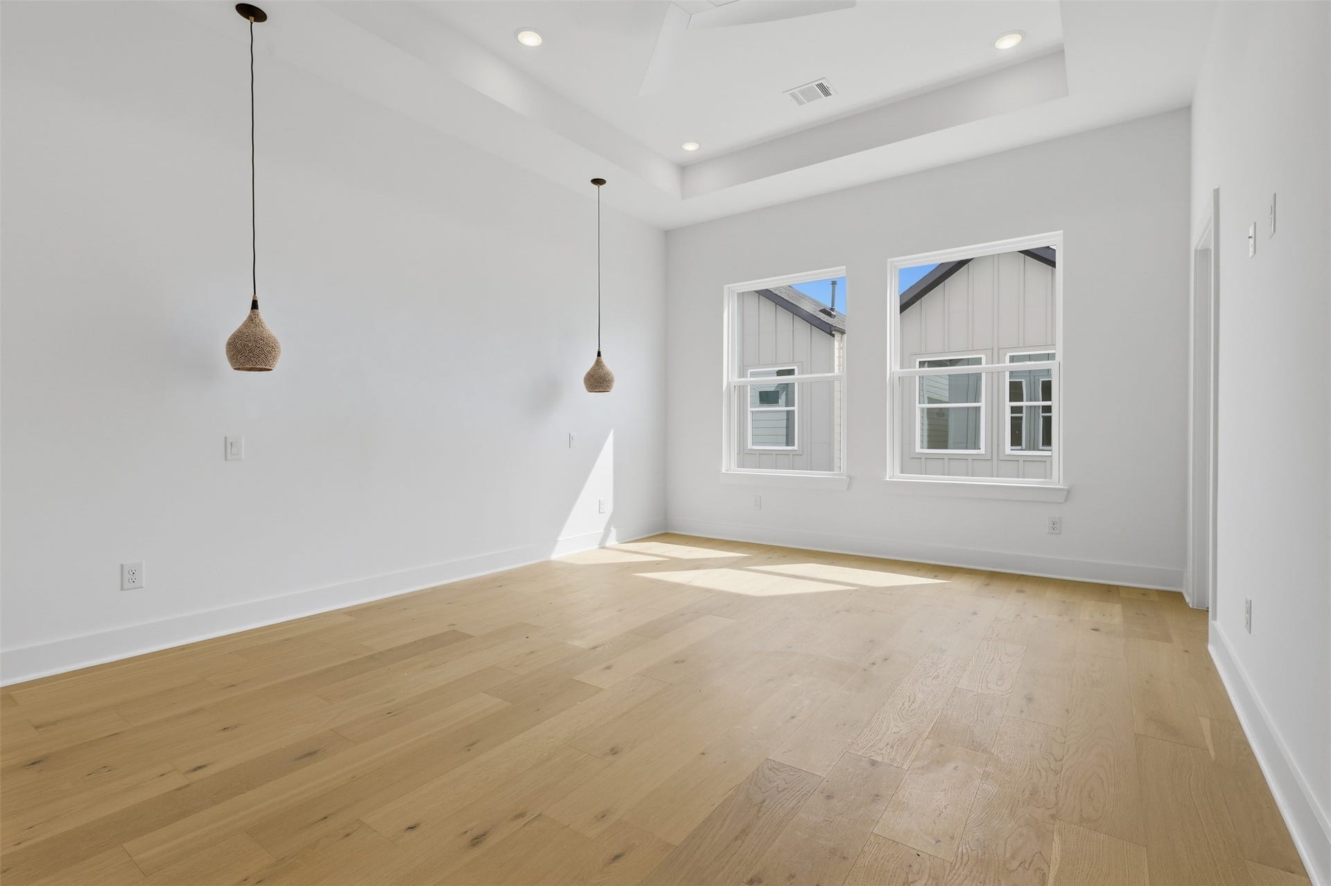 The primary bedroom offers a place to unwind, with pendant lights beside the space for a bed.