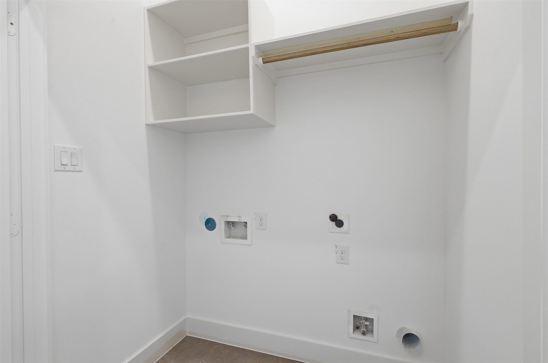The tour finishes with the laundry space, equipped with appliance connections and shelving.