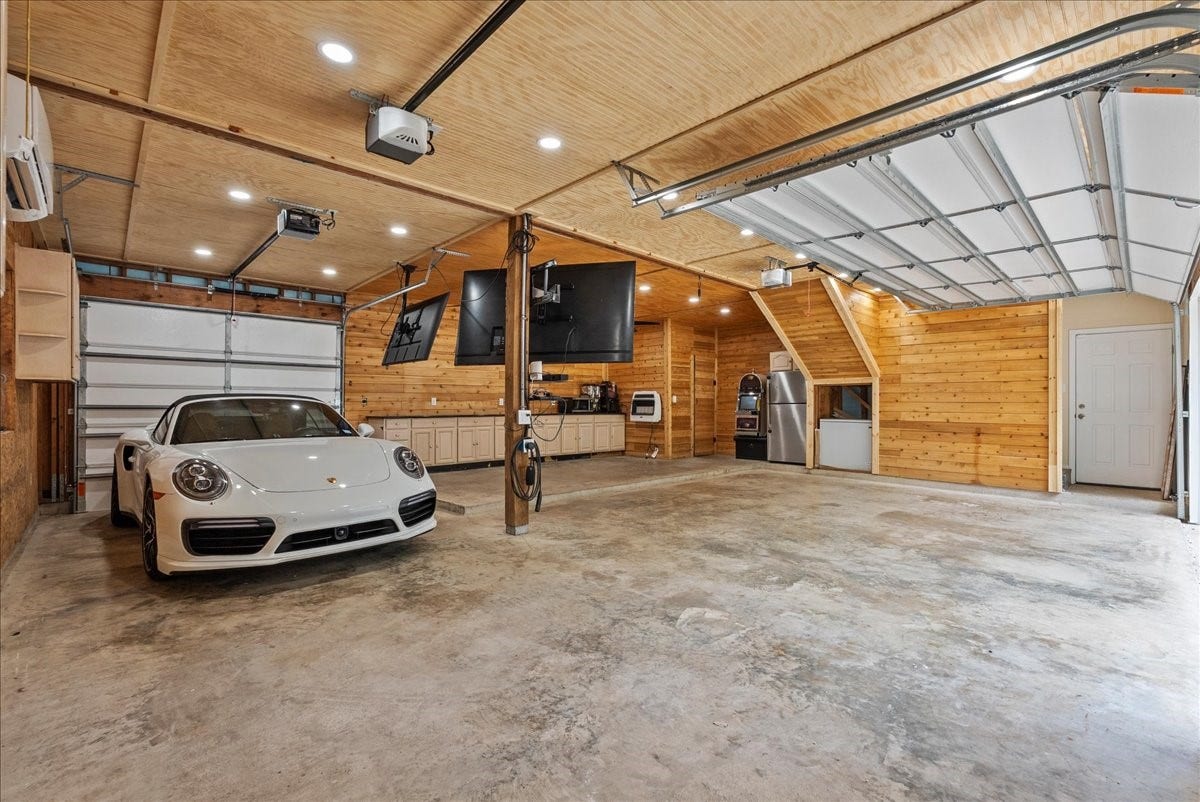 9700 Jay Road, Hitchcock, TX 77563 A rare find, this oversized climate-controlled garage offers the perfect blend of function and flexibility with four garage doors, a downstairs half bath, and plenty of room for vehicles, storage, or your favorite projects. This impressive space elevates the home beyond the ordinary and provides comfort year-round.