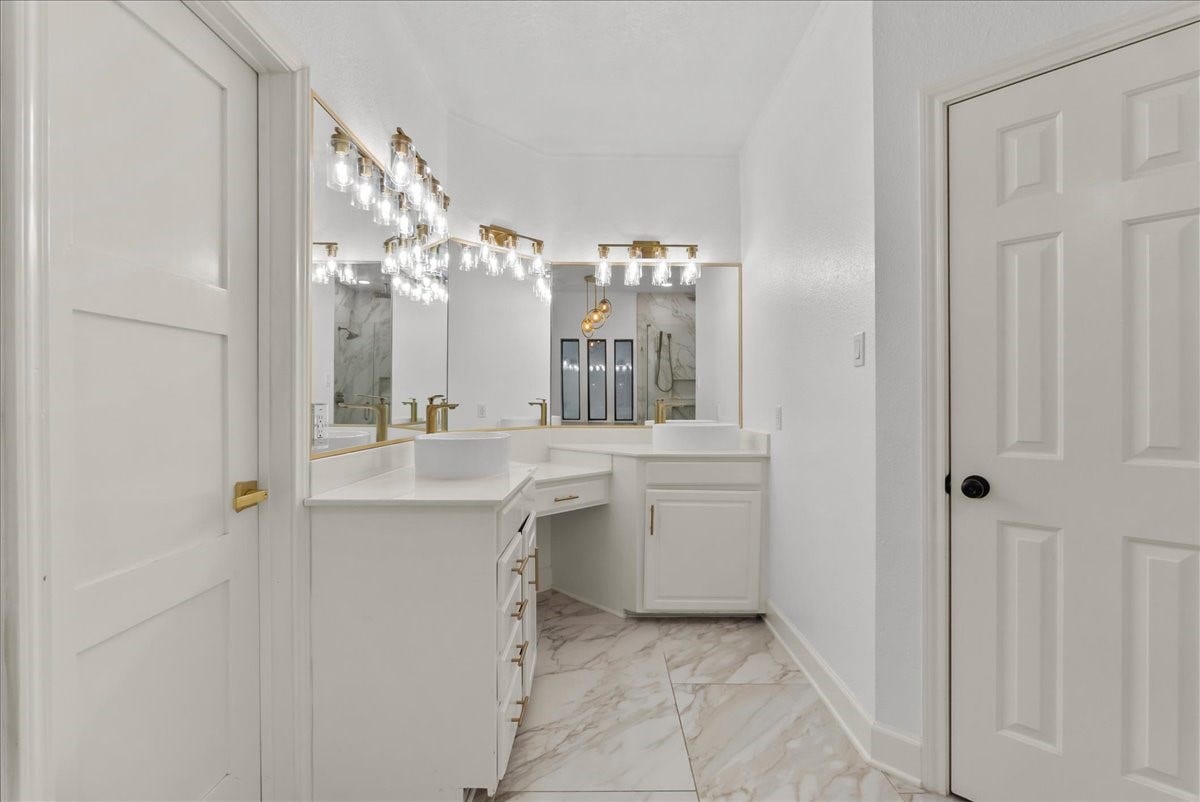 9700 Jay Road, Hitchcock, TX 77563 Designed for both beauty and function, this elegant primary retreat features separate vanities with a dedicated sitting area and an expansive walk-in closet offering exceptional space and storage.