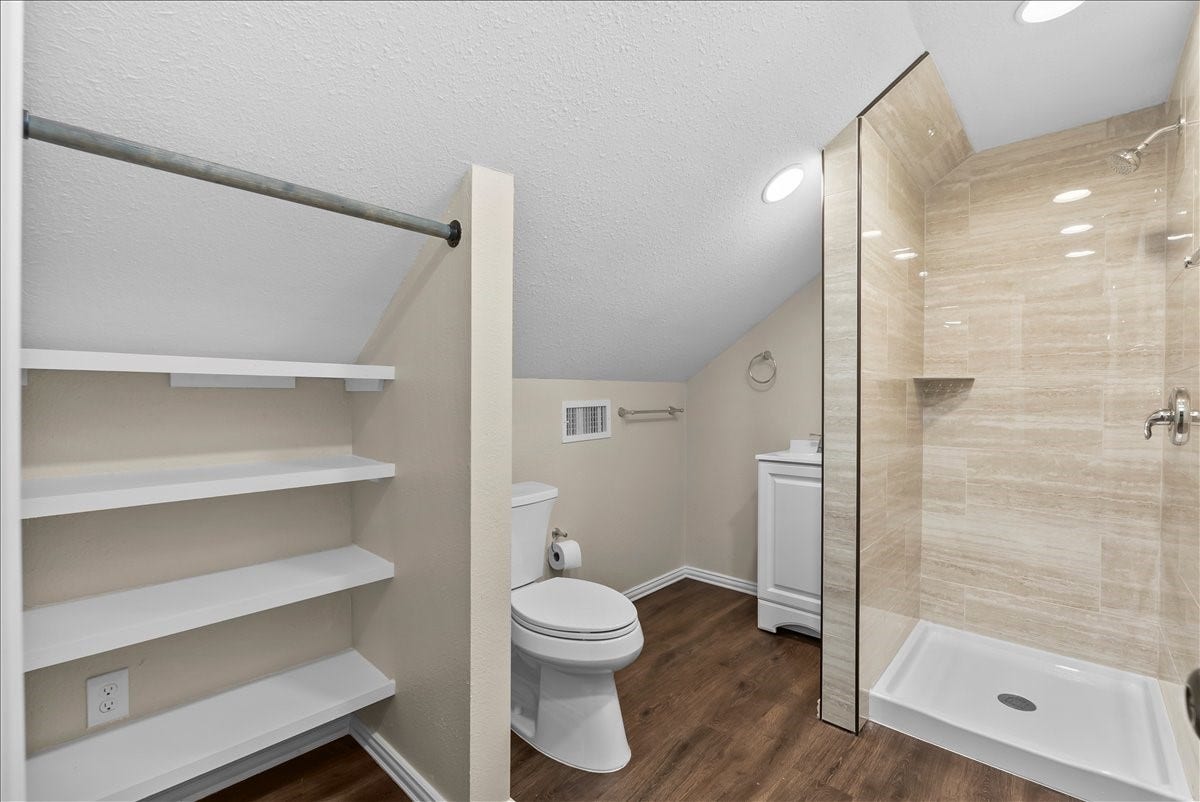 9700 Jay Road, Hitchcock, TX 77563 The second level of the garage features a newly renovated full bathroom showcasing a sleek walk-in shower with floor-to-ceiling tile, creating a comfortable and stylish space for guests, hobbies, or flexible living needs.