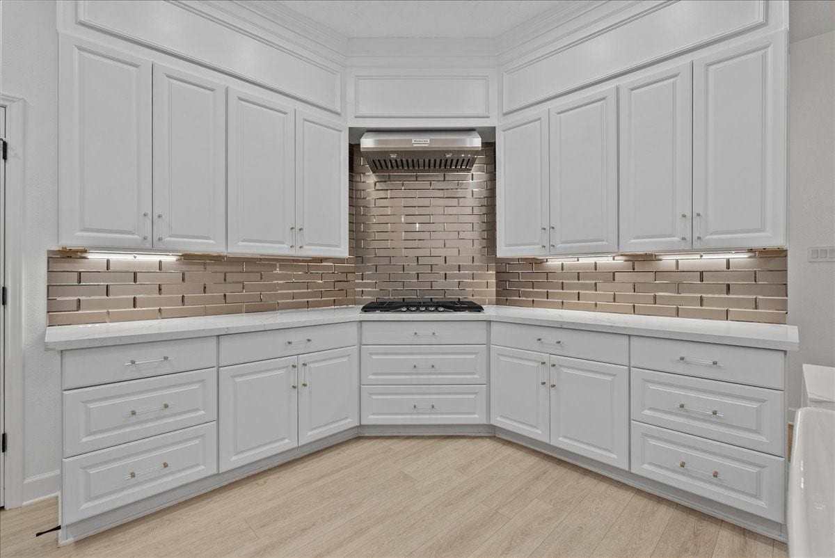 9700 Jay Road, Hitchcock, TX 77563 Luxury is found in every detail, from the rich gold hardware and fixtures to the sleek gold subway tile backsplash, creating a sophisticated yet inviting atmosphere.