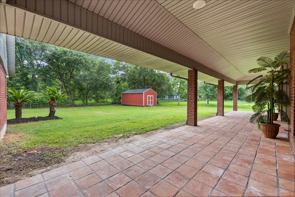9700 Jay Road, Hitchcock, TX 77563 An entertainers dream awaits with an extra-large covered porch spanning the length of the home, offering the perfect space for relaxing or gatherings. Enjoy the added convenience of a storage shed and cozy up around the brick firepit for unforgettable evenings outdoors.