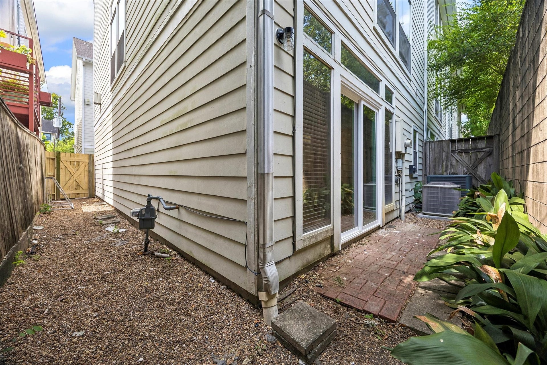 Going around the corner, the house enjoys a "side" yard as well, with gate access to the shared community driveway! Simple pea-gravel ground cover for an easy-to-maintain yard space!
