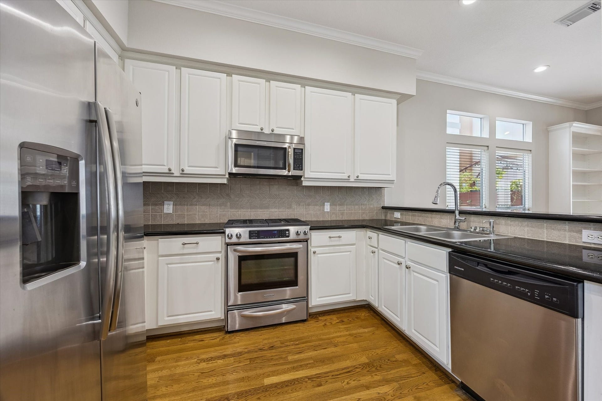 Kitchen is a perfectly efficient layout with plenty of granite countertop space, cabinets, and stainless-steel finish appliances!