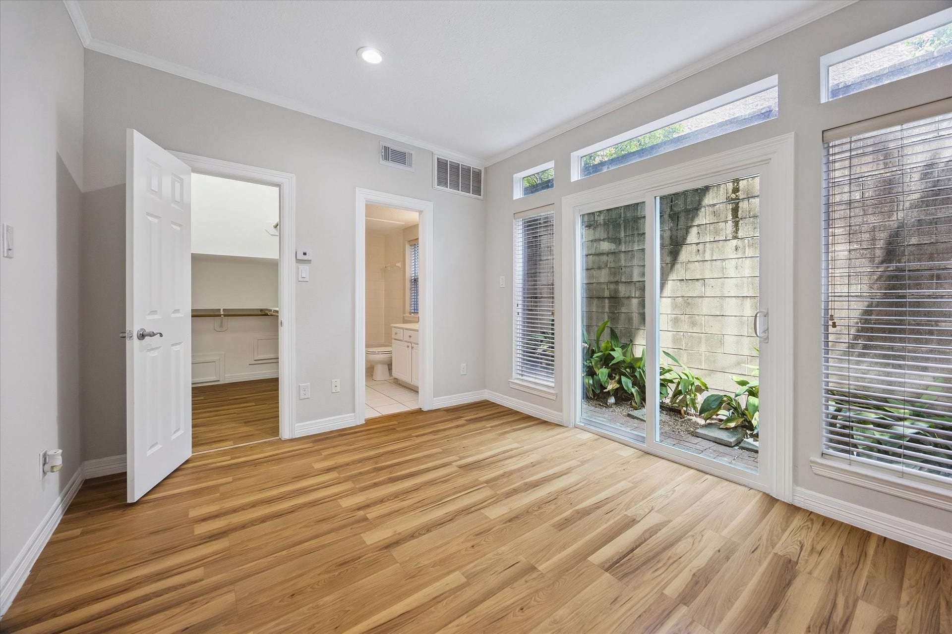On first floor is a great-size secondary bedroom flooded with natural light! Bedroom offers en-suite bathroom and a HUGE walk-in closet PLUS direct access to back and side yards!