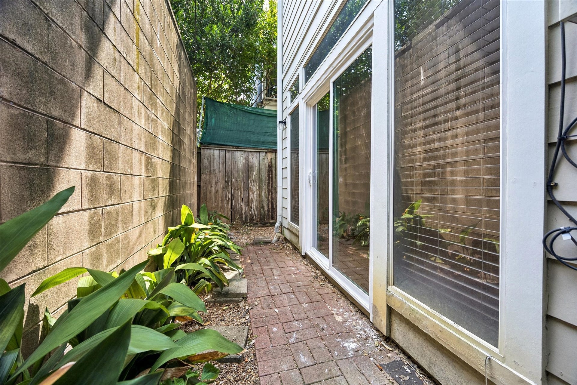 "Back" yard is lovely and shaded and has patio stones laid out already, perfect for a small bistro table and chairs and/or BBQ! Some simple landscaping adds a touch of green!