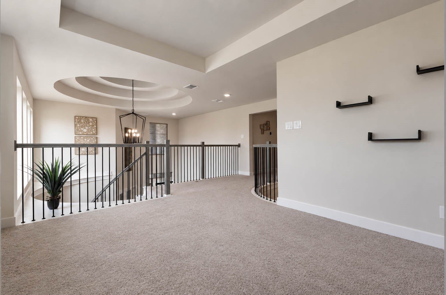 3165 Stingray Cove Drive, Katy, TX 77493 An alternate view of the spacious game room highlights its open connection to the catwalk and dramatic two-story entry below. A tray ceiling, plush carpeting, & generous proportions create an elevated yet comfortable space with plenty of room for seating, games, or entertaining.