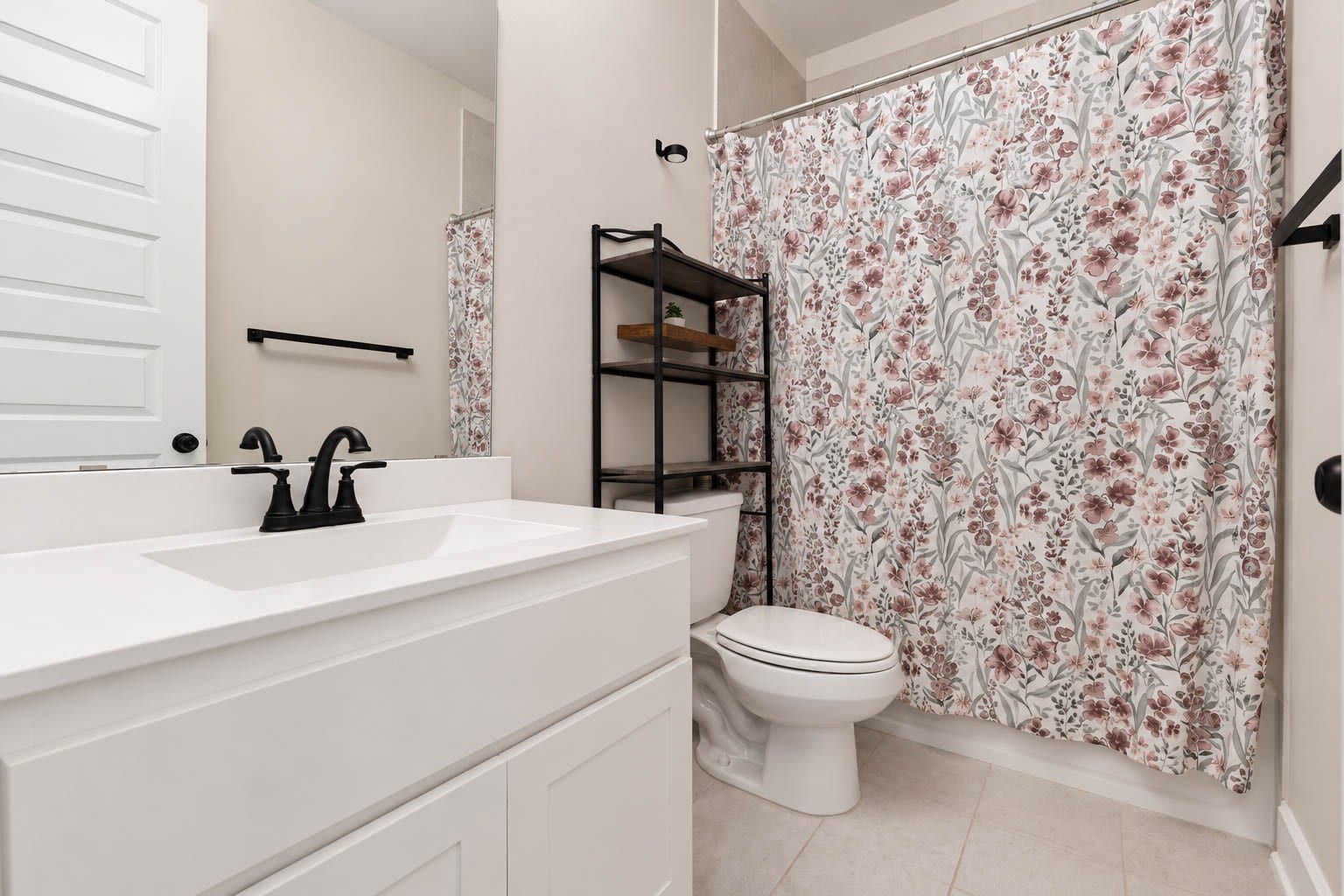 3165 Stingray Cove Drive, Katy, TX 77493 The adjoining private bath is beautifully finished with a crisp white vanity, sleek quartz countertop, oversized mirror, and contrasting matte fixtures. A tub/shower combination completes the space, giving this first-floor bedroom the privacy and convenience of its own ensuite bath.