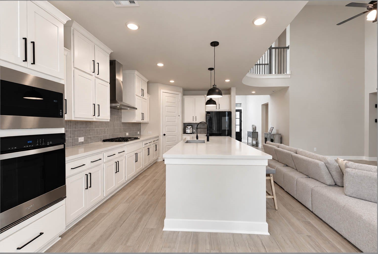 3165 Stingray Cove Drive, Katy, TX 77493 The thoughtfully designed space features a stainless steel built-in oven & microwave, gas cooktop with vent hood, & expansive center island with a farmhouse sink, generous workspace, additional storage, & breakfast-bar seating. A spacious walk-in pantry completes this impressive kitchen with even more storage.