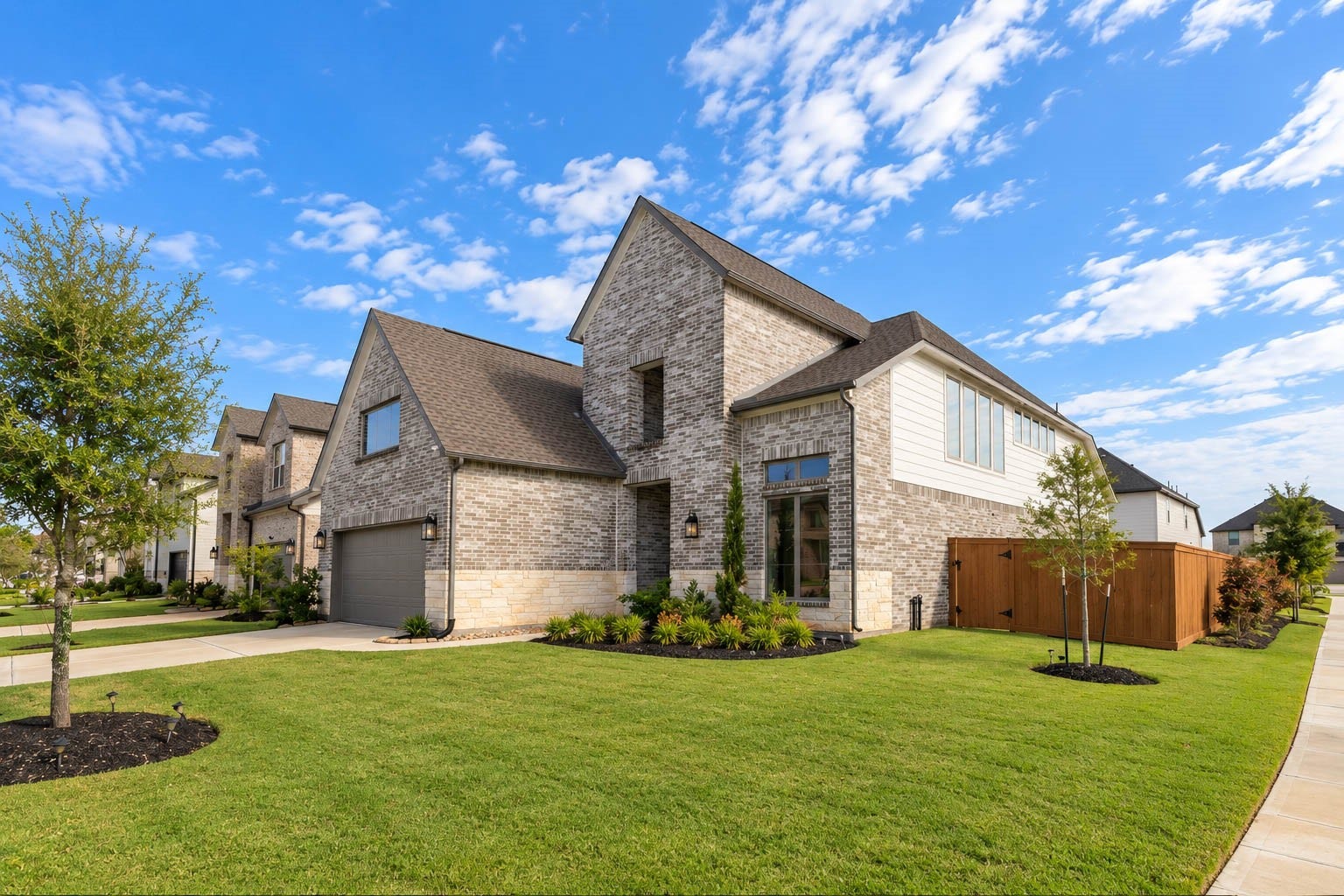 3165 Stingray Cove Drive, Katy, TX 77493 A striking front elevation welcomes you with dramatic rooflines, handsome brickwork, stone accents, and contemporary exterior lighting. The attached garage and manicured lawn complement the homes clean architectural lines, while the corner setting allows the residence to make an especially impressive first impression.