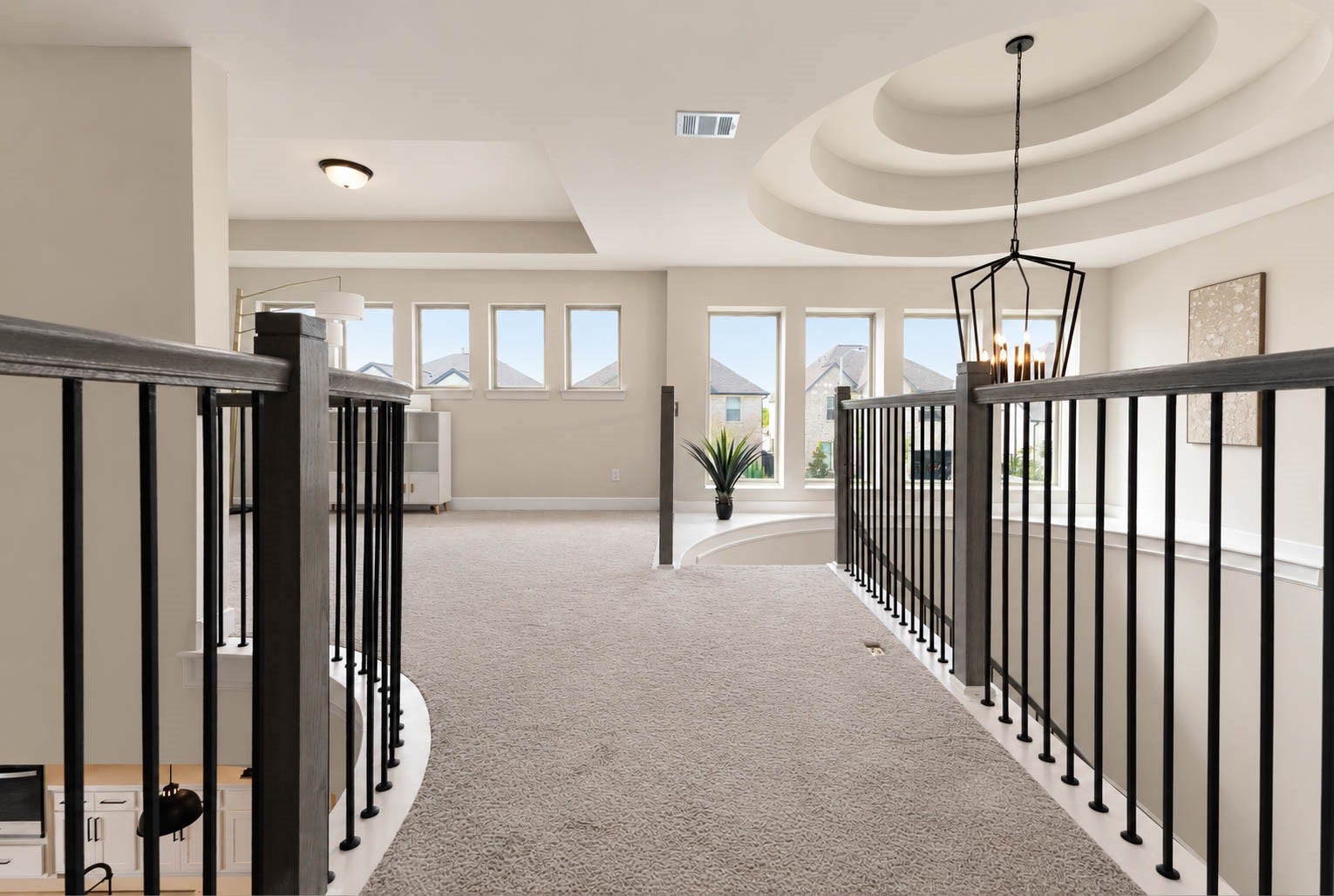 3165 Stingray Cove Drive, Katy, TX 77493 A beautifully designed catwalk connects the upper level, offering a striking view of the homes impressive architecture. Overhead, a dramatic tiered ceiling frames the statement chandelier, creating an elegant focal point.