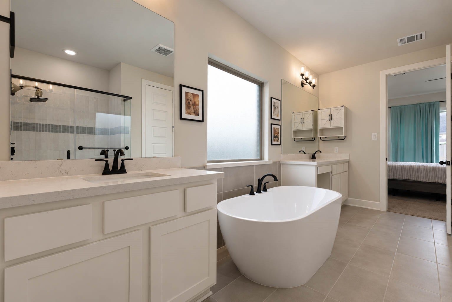 3165 Stingray Cove Drive, Katy, TX 77493 Designed with relaxation in mind, the primary bath centers around a beautiful freestanding soaking tub framed by separate vanity areas. Light cabinetry, generous mirrors, stylish dark fixtures, and elegant lighting give the space a fresh, sophisticated finish.