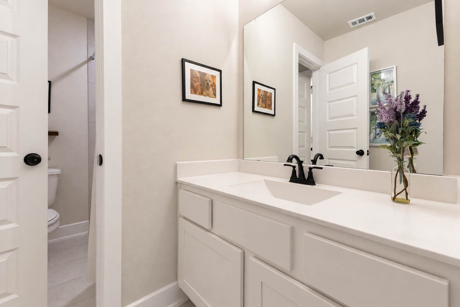 3165 Stingray Cove Drive, Katy, TX 77493 Completing the secondary suite, this ensuite bath features a generous white vanity with a sleek quartz countertop, large mirror, and matte fixtures. The adjoining bath area adds privacy and convenience, making this bedroom especially well suited for guests or household members.