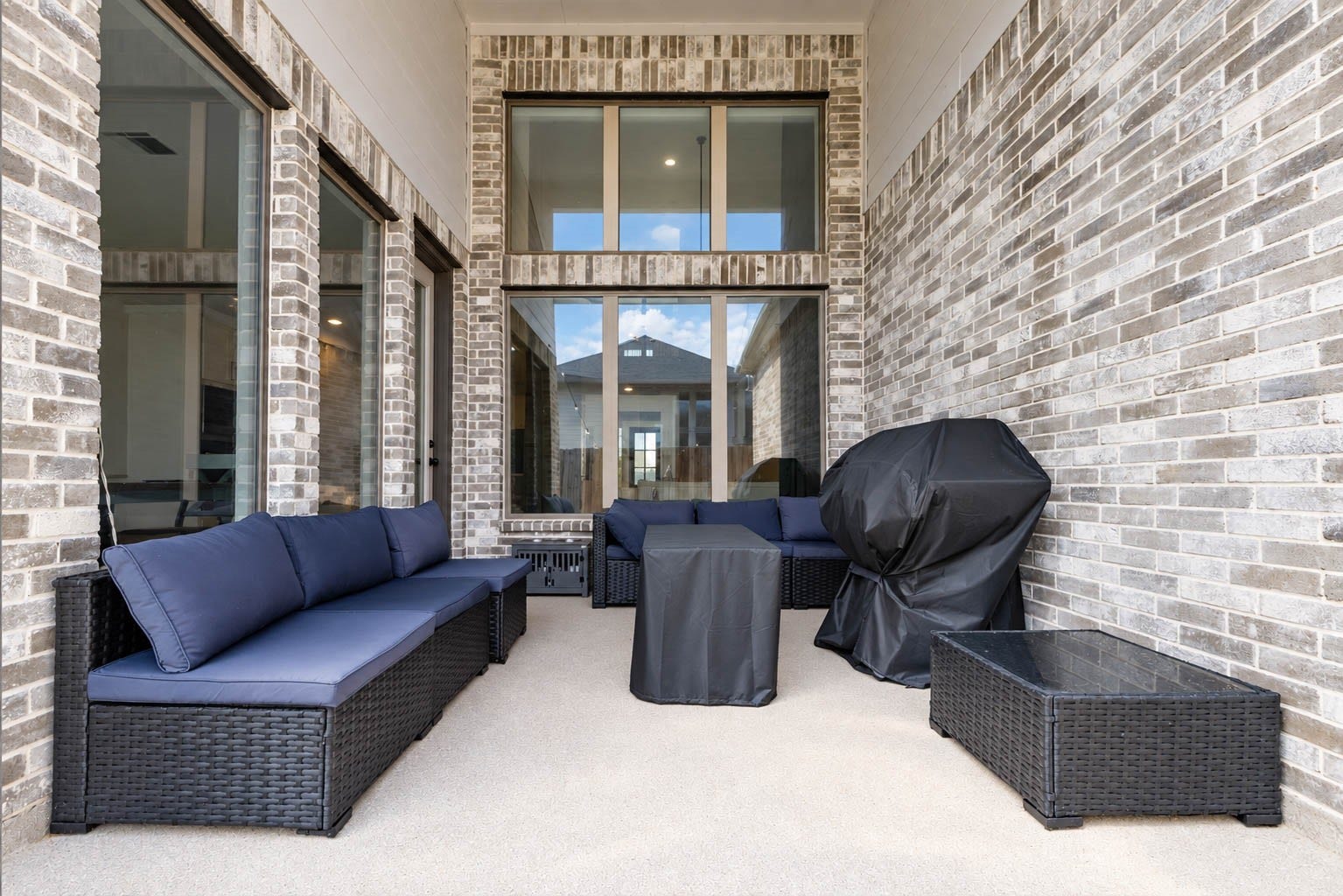 3165 Stingray Cove Drive, Katy, TX 77493 The covered patio provides a comfortable setting for morning coffee, casual meals, or evenings outdoors. Generous proportions accommodate multiple seating areas, while towering windows create a dramatic connection to the interior living spaces.