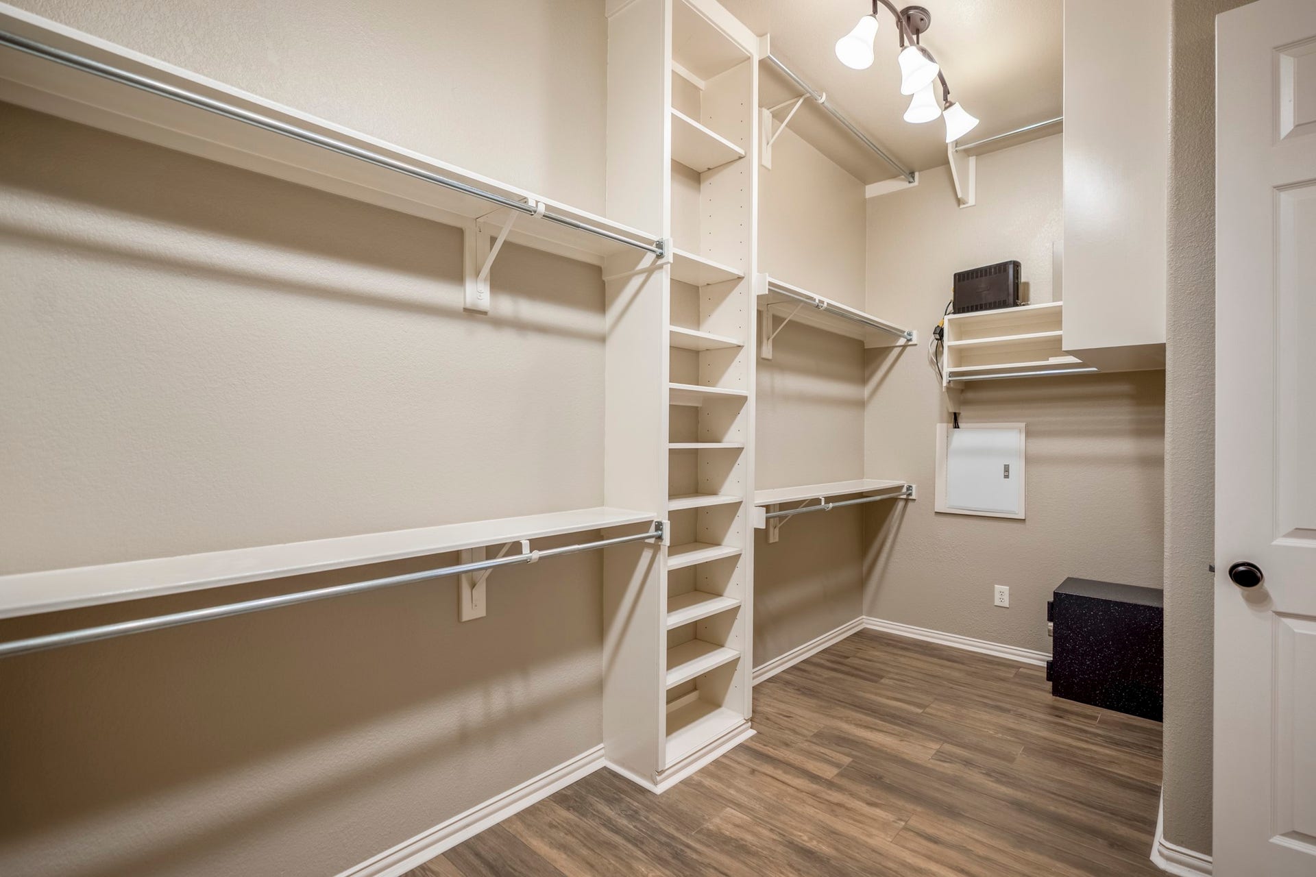 2407 Hendricks Lakes Drive, Spring, TX 77388 Continuing from the remodeled primary bath, the walk-in closet adds a well-planned extension of the suite with wraparound shelving, hanging space, and wide-plank wood-look tile carried through from the bedroom and bath. Its direct connection to the bath keeps the primary retreat feeling seamless, with storage placed right where buyers would expect it.