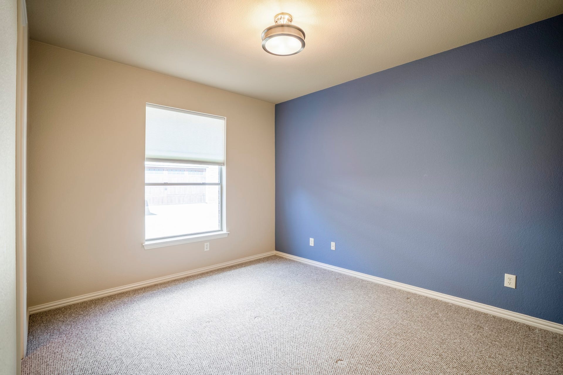 2407 Hendricks Lakes Drive, Spring, TX 77388 Returning to the front of the home, this secondary bedroom suite sits near the office/study and offers a quieter transition from the main living areas. The window brings in natural light, while the blue accent wall adds contrast and gives the room a defined, finished feel before the walkthrough continues into the nearby bath.