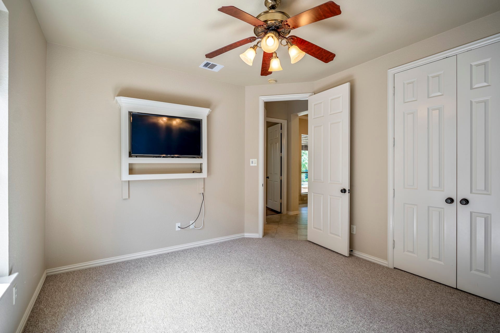 2407 Hendricks Lakes Drive, Spring, TX 77388 The fourth bedroom shows the closet doors along the right wall and the doorway leading back toward the nearby hall. From here, the walkthrough transitions toward the stairs, moving from the downstairs bedroom spaces up to the game room and media room above.