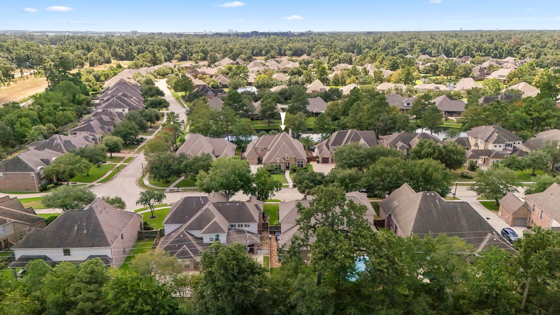 2407 Hendricks Lakes Drive, Spring, TX 77388 Wide neighborhood views show how Lakes of Cypress Forest is shaped around water, greenery, and a gated community setting that feels tucked into the trees. With lakes, paths, and established homes throughout the neighborhood, this perspective helps buyers connect the homes water-front backyard and poolside lifestyle to the larger community around it.
