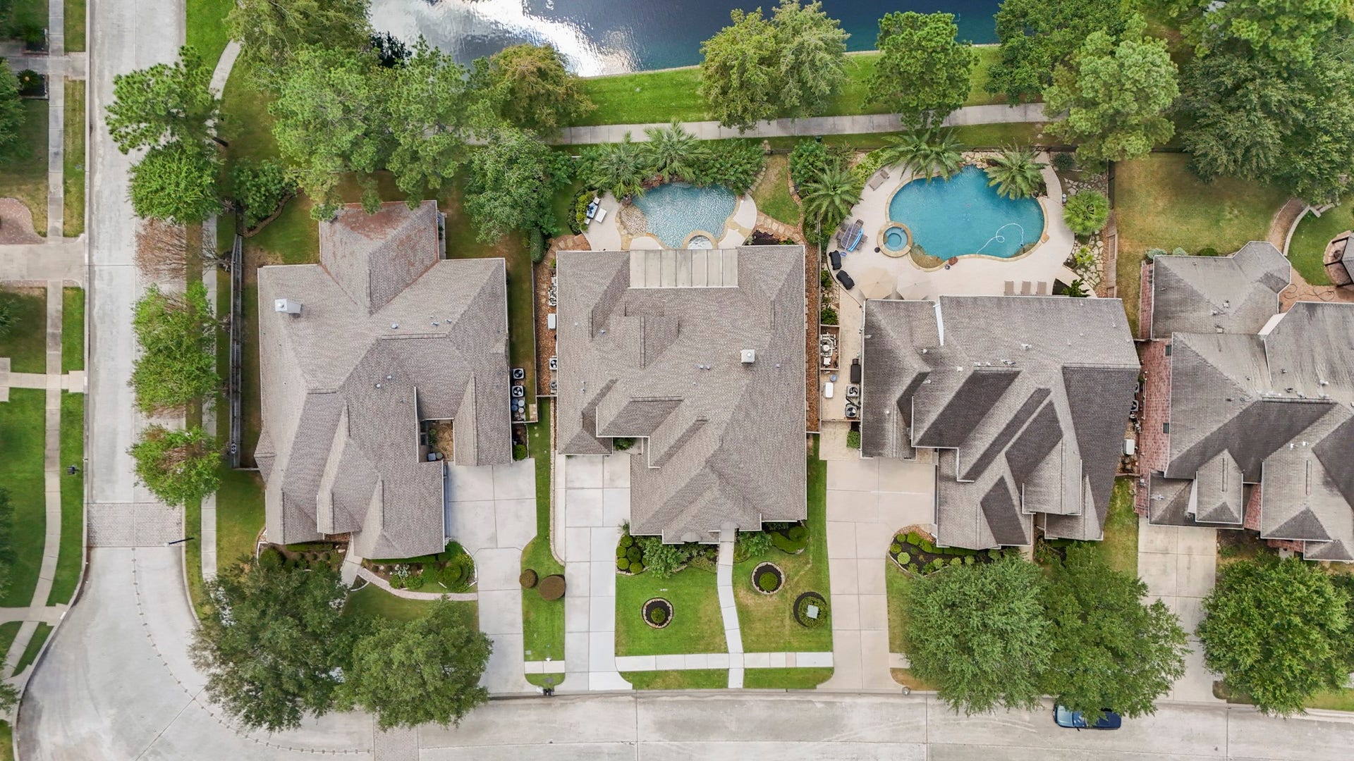 2407 Hendricks Lakes Drive, Spring, TX 77388 From above, the homes layout shows how closely the outdoor spaces are tied to the water-front setting, with the pool, raised spa, and covered patio tucked between the home and the water beyond. The front drive and garage space face the street, while the backyard opens toward the trails and greenery, giving buyers a clear look at how the home is positioned for both privacy and poolside living.