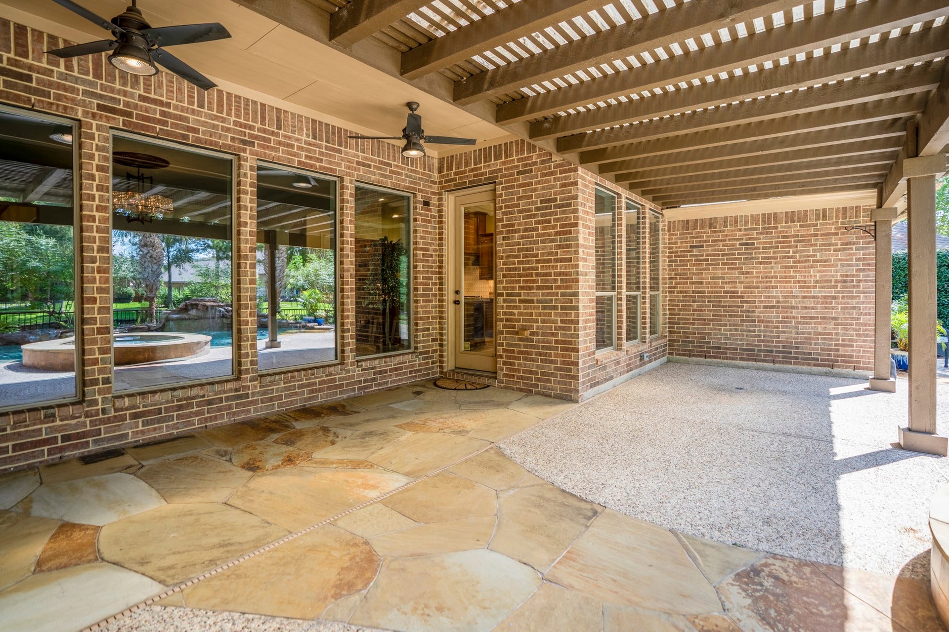 2407 Hendricks Lakes Drive, Spring, TX 77388 Beneath the 30 covered pergola, the back patio feels like an outdoor living space made for shaded afternoons, rainy-day coverage, and slower evenings by the water. Stone flooring, substantial support posts, and the covered structure extend the homes living space outside, while the windows and doors keep the patio connected to the living room and breakfast nook just inside.
