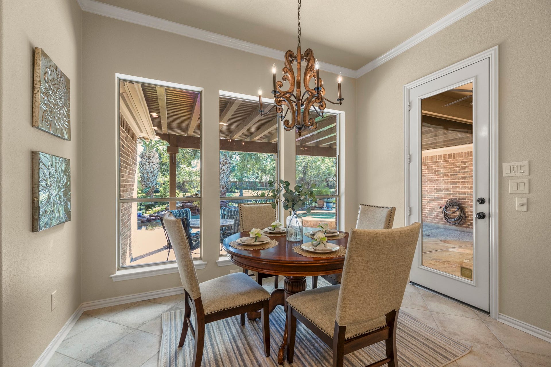 2407 Hendricks Lakes Drive, Spring, TX 77388 Breakfast nook sits just beyond the kitchen, wrapped in windows that draw in natural light and keep the poolside, water-front backdrop in view. The glass door on the right opens to the covered outdoor living area, making this an easy spot for morning coffee before heading out toward the pool, spa, and backyard beyond. Along the left side, the hallway leads to two secondary bedrooms and a full bath.