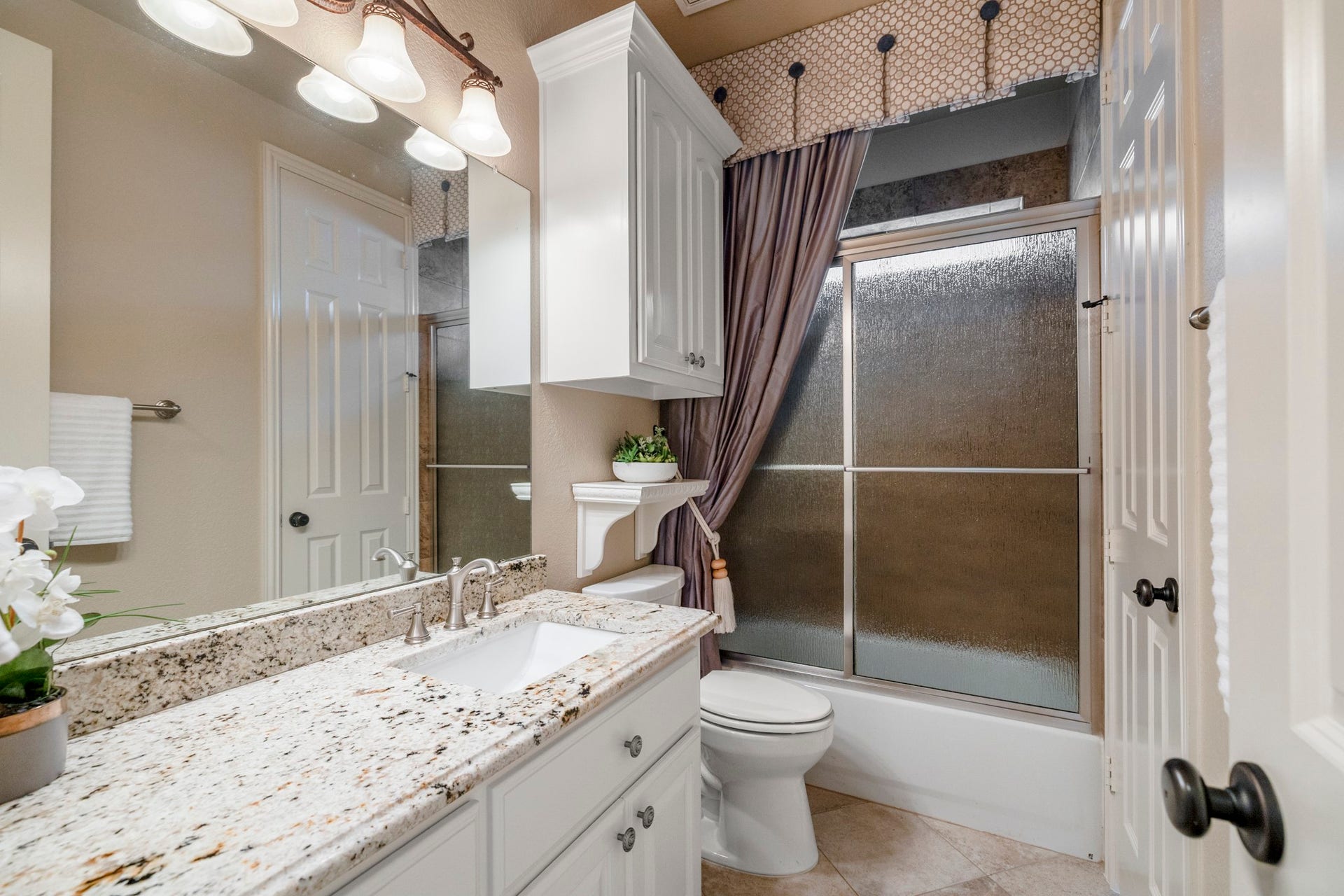 2407 Hendricks Lakes Drive, Spring, TX 77388 Serving the two rear secondary bedrooms, this bath keeps the back-of-home wing polished and convenient without pulling attention away from the homes main living spaces. The framed mirror, upgraded lighting, vanity storage, and tiled tub/shower surround give the space a finished feel as the walkthrough continues between the nearby bedrooms.