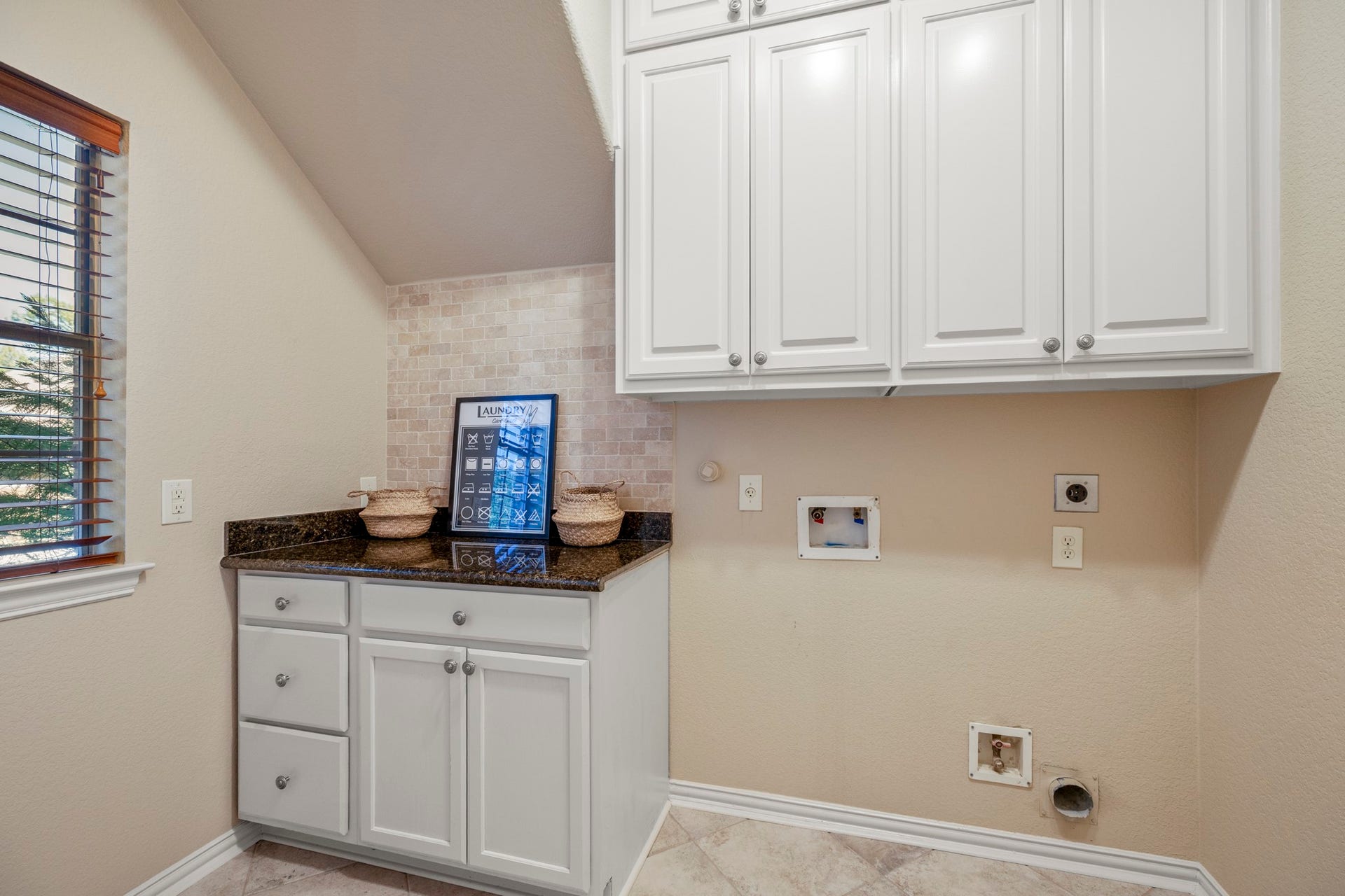 2407 Hendricks Lakes Drive, Spring, TX 77388 Positioned in the hallway between the dining room and kitchen, the utility room downstairs keeps laundry tucked close to the homes main living spaces without interrupting the flow. Built-in cabinetry, counter space, hanging space, and upper storage give the room a practical, finished feel as the walkthrough returns from upstairs and continues toward the outdoor living areas.