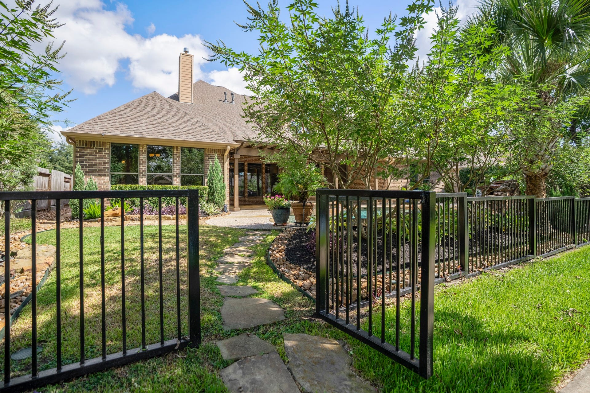 2407 Hendricks Lakes Drive, Spring, TX 77388 Stepping through the backyard gate, the homes water-front lifestyle continues onto the neighborhood trails just beyond the fence. The black wrought-iron fencing keeps the backyard visually connected to the lakeside setting, so the pool, covered pergola, and outdoor living spaces feel tied to the paths, water, and greenery that make Lakes of Cypress Forest so memorable.