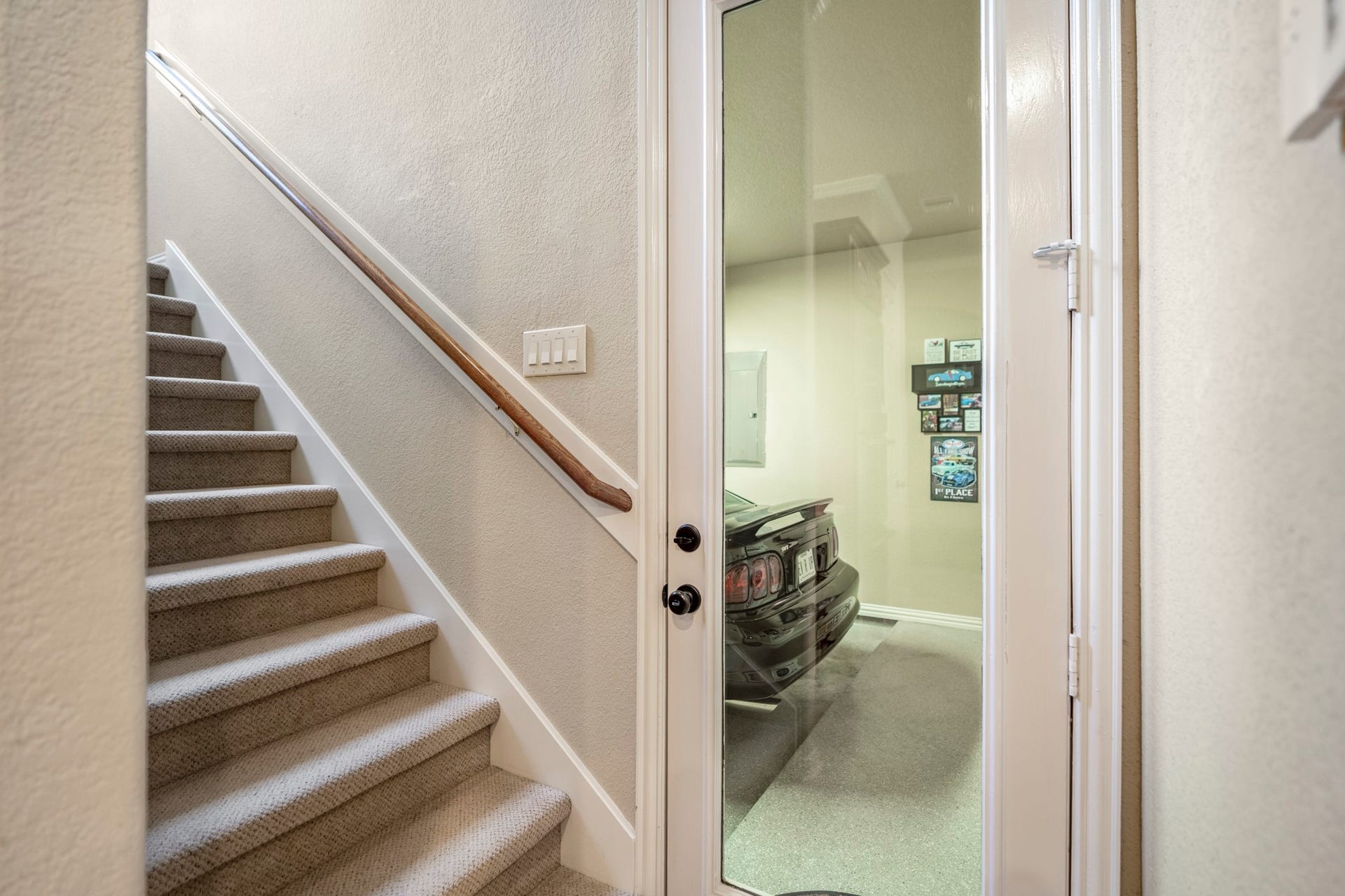 2407 Hendricks Lakes Drive, Spring, TX 77388 Just off the side of the kitchen, this hallway gives buyers a helpful look at how the homes upstairs spaces and garage layout connect. The stairs lead up to the game room, media room, and half bath, while the nearby access to the separate third garage bay shows how the home offers 3-car garage space while keeping that single bay distinct from the main 2-car garage.