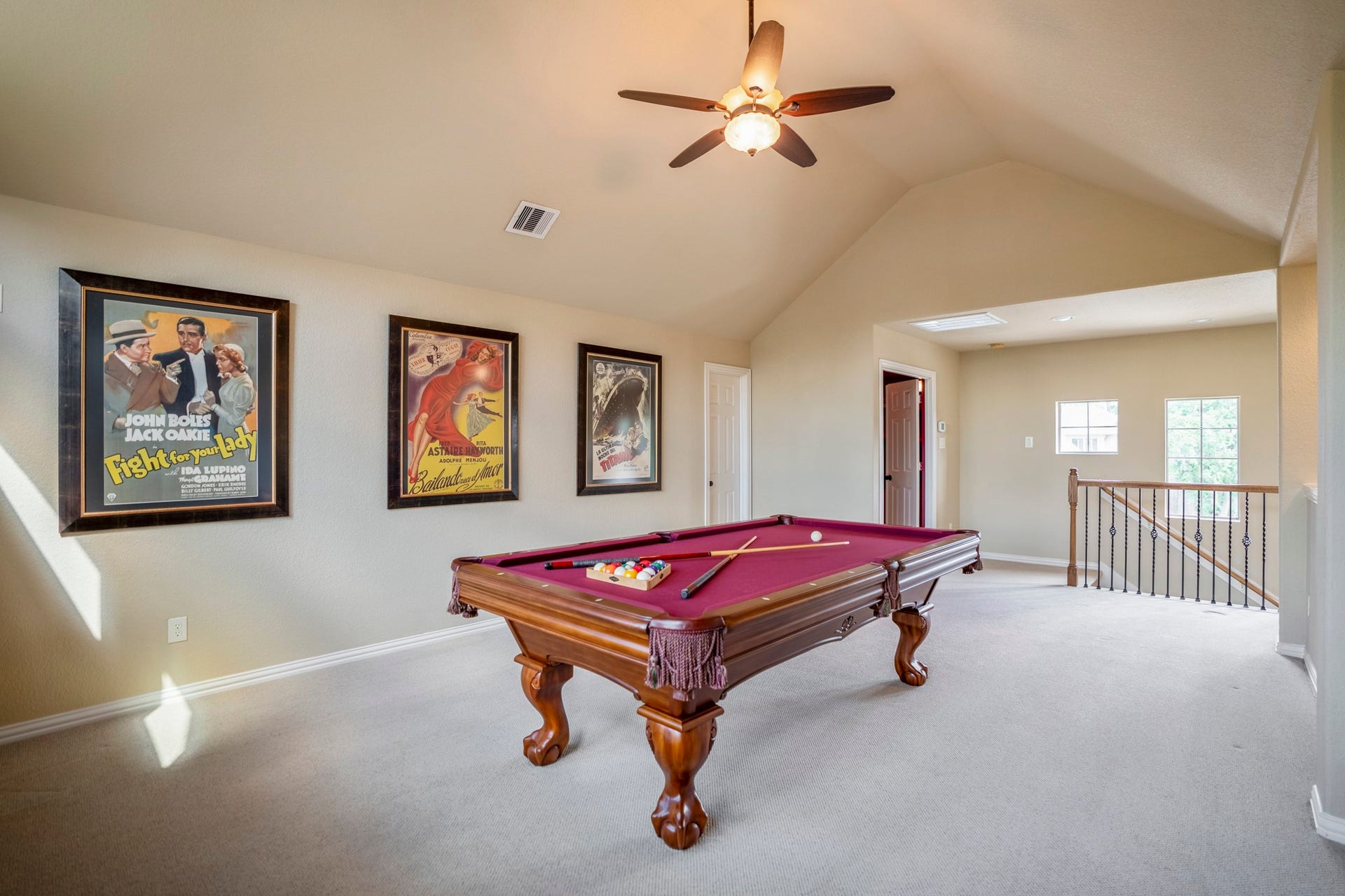 2407 Hendricks Lakes Drive, Spring, TX 77388 From this angle, the upstairs game room shows how the second level is set up for relaxed entertaining, with the pool table centered in the space and windows bringing in natural light. The door on the left leads to the half bath, while the door across from the stairs opens to the media room, keeping the upstairs layout easy to enjoy for game nights, movies, and time away from the main living areas downstairs.